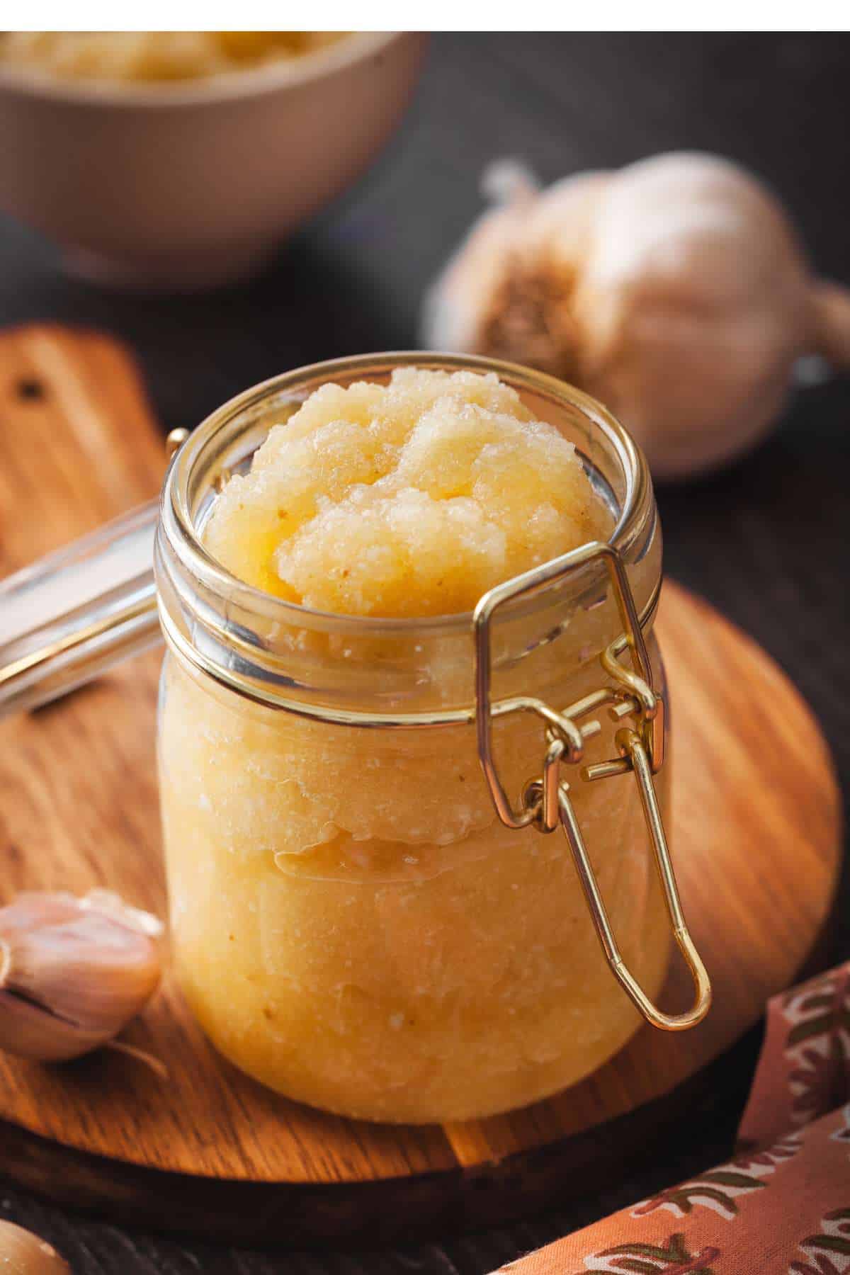 A glass jar filled with garlic puree.