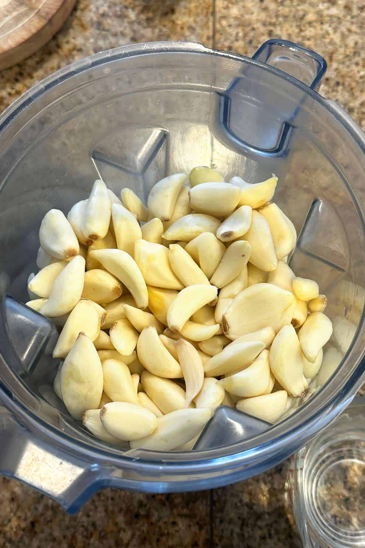 Peeled garlic cloves in a blender jar.