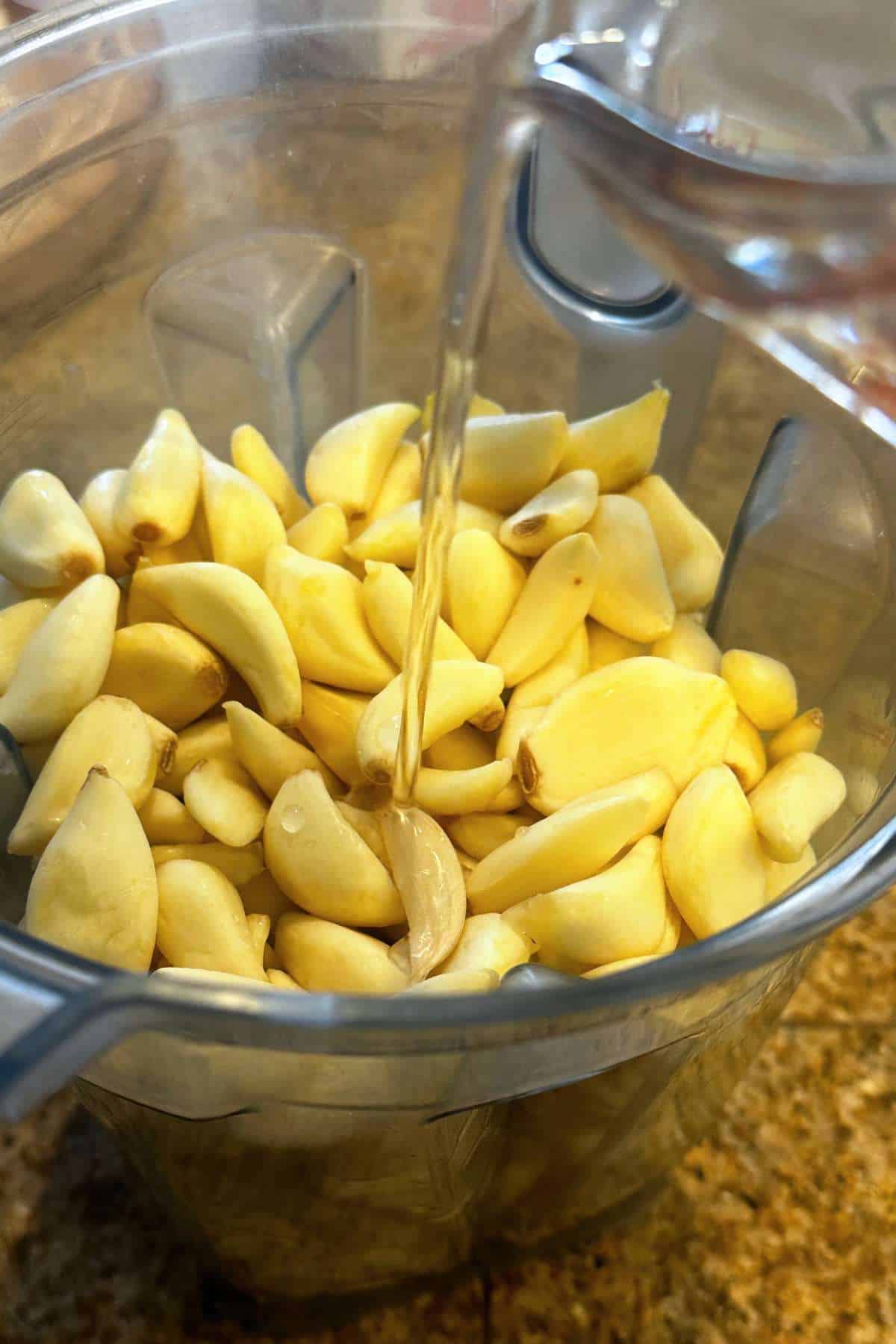 Adding oil to the garlic cloves.