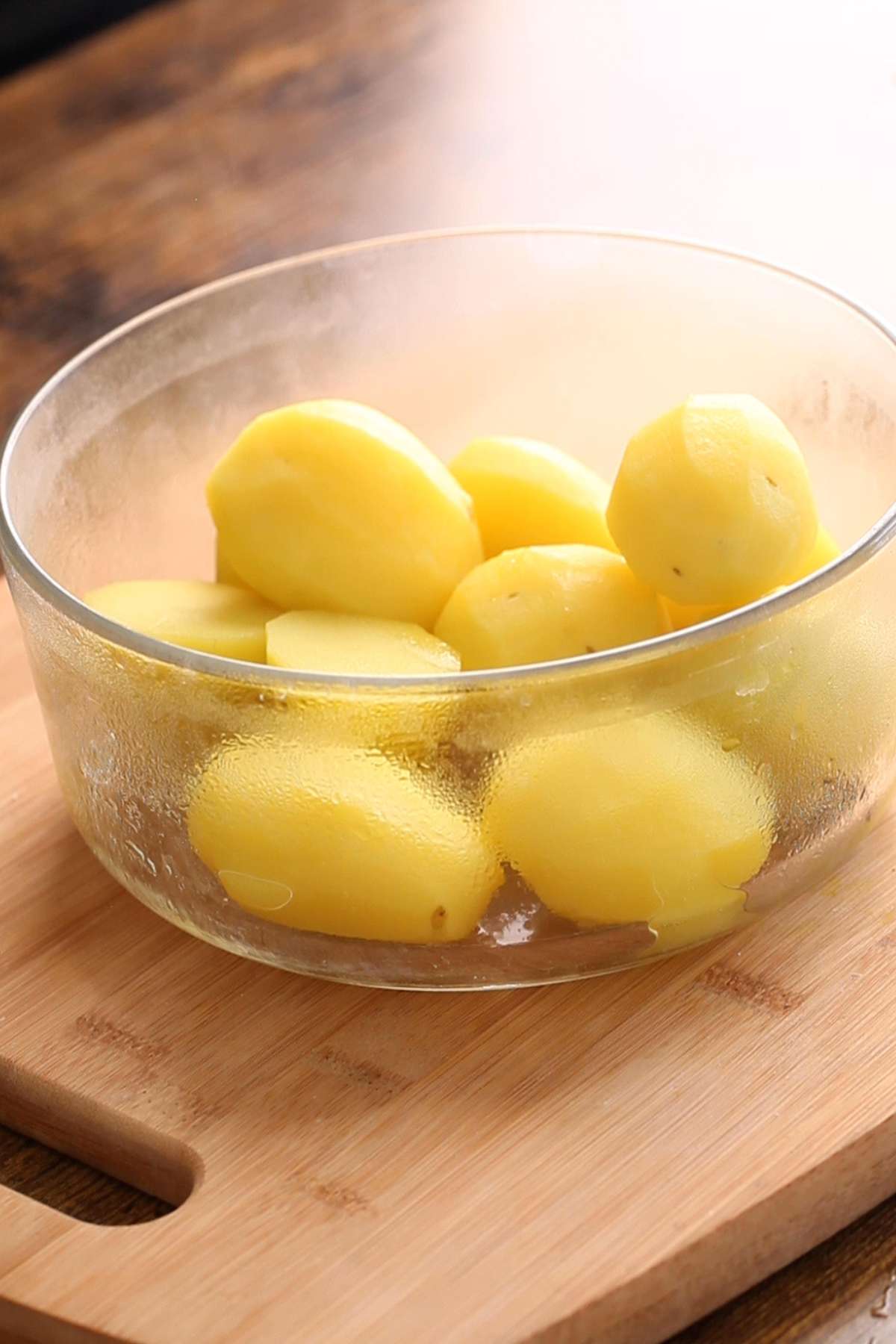 Par boiled potatoes boiled and placed in a glass bowl.