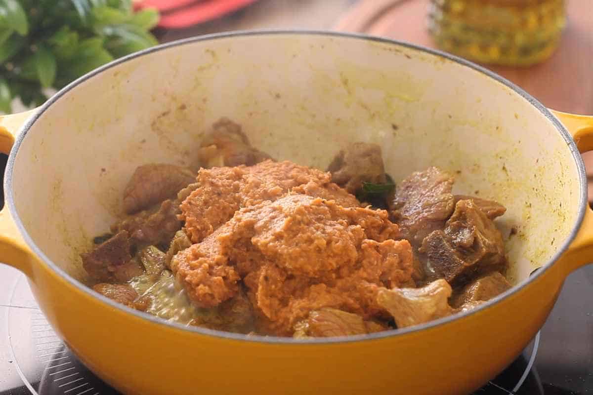 Add the madras spice paste to the lamb.