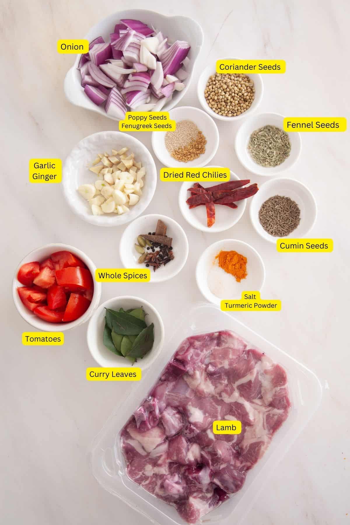 Ingredients needed to cook lamb madras placed on a white marble board.