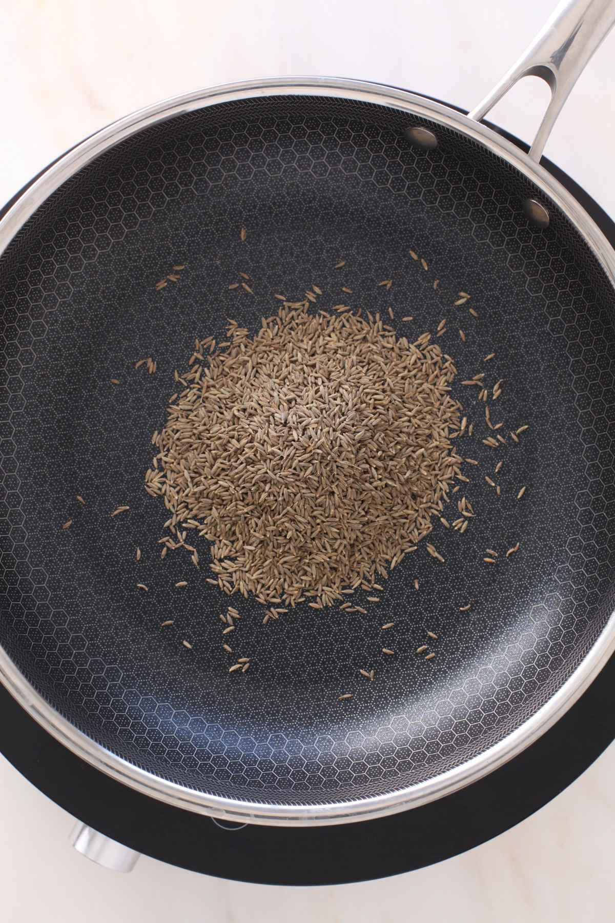 Cumin seeds placed in a pan. 
