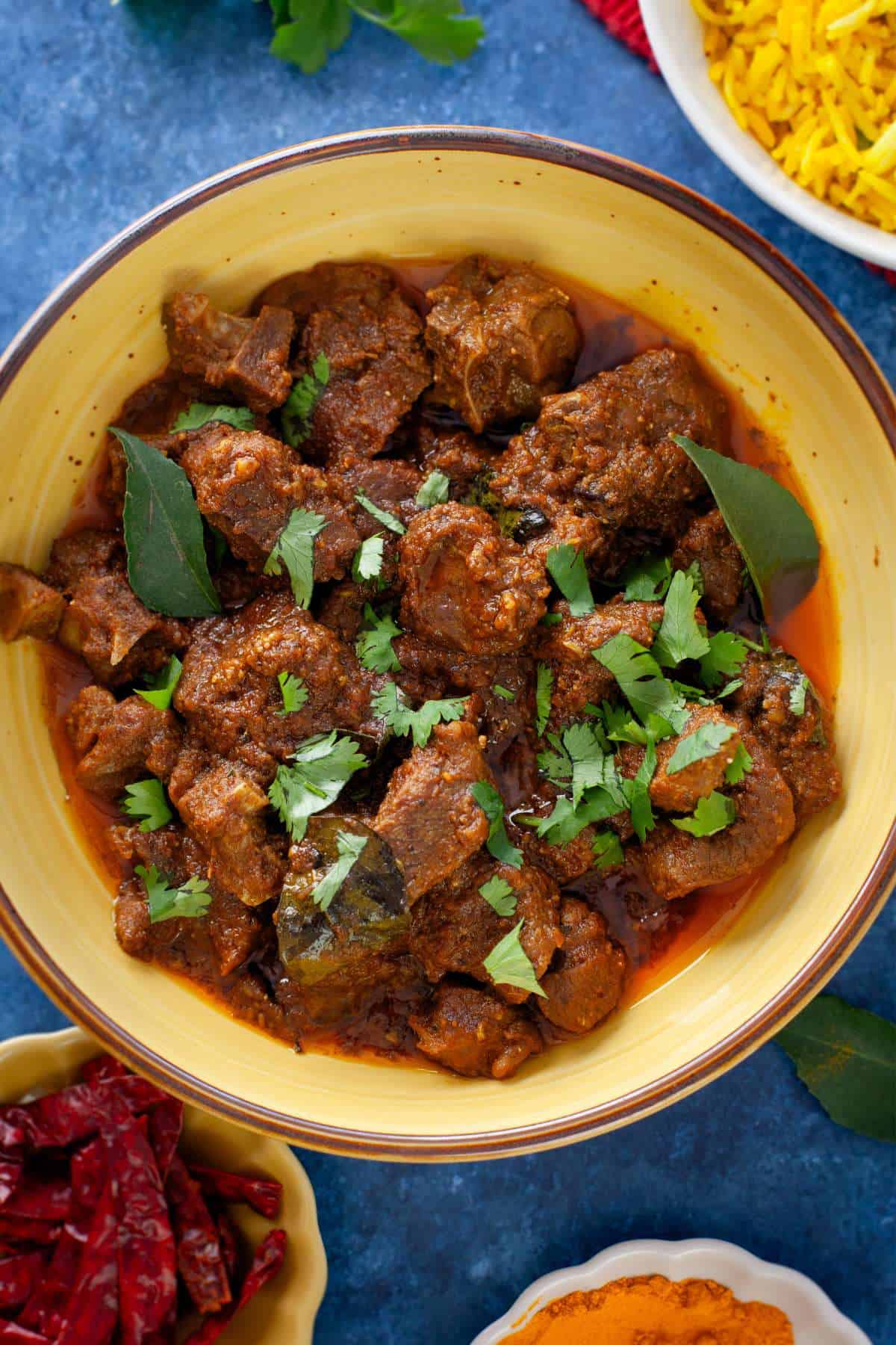 Close up of lamb madras served in a yellow bowl.