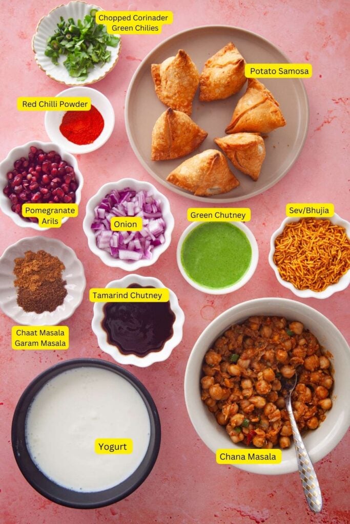 Ingredients needed for plating samosa chaat place on a pink background.