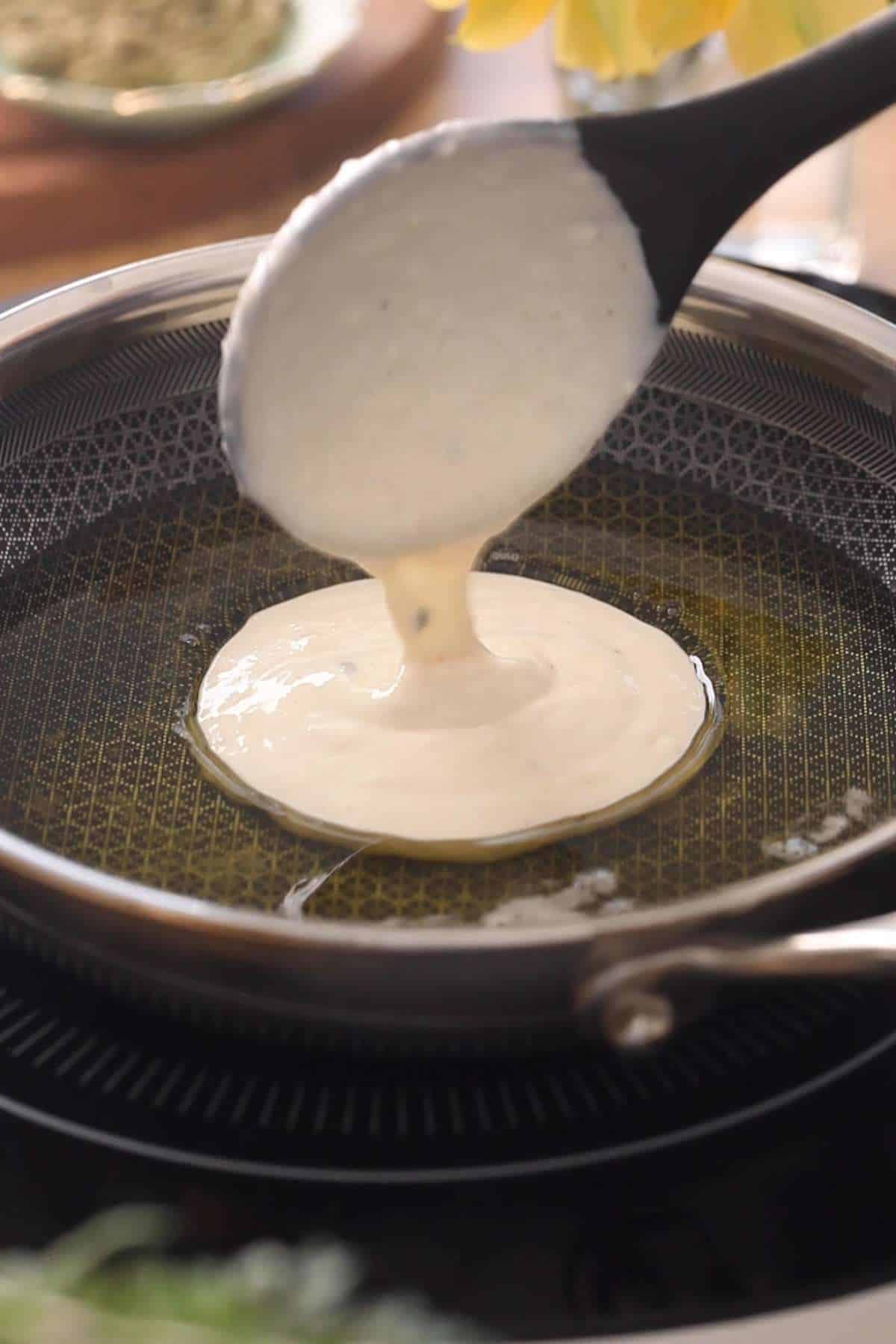 Pouring batter into warm ghee for frying.