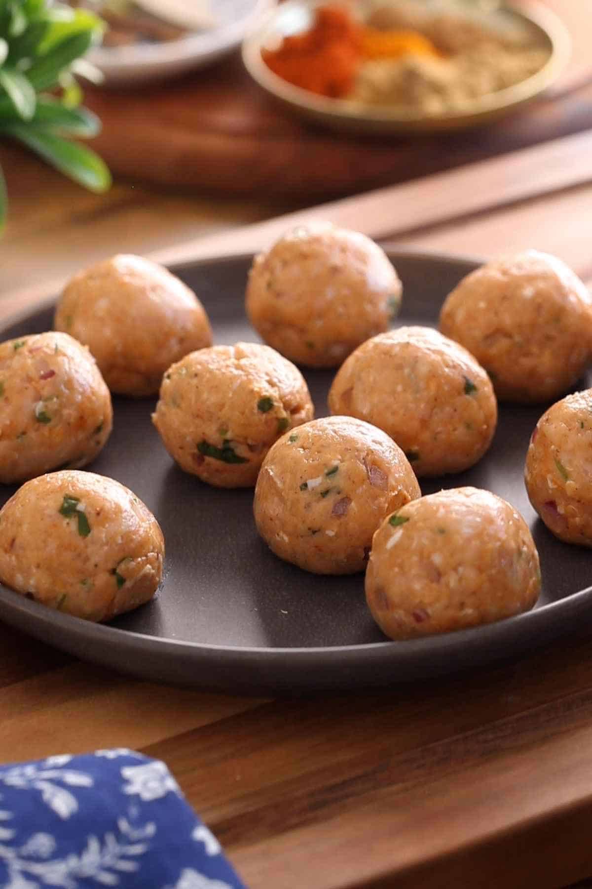 Raw Chicken Kofta shaped and placed on a grey plate.