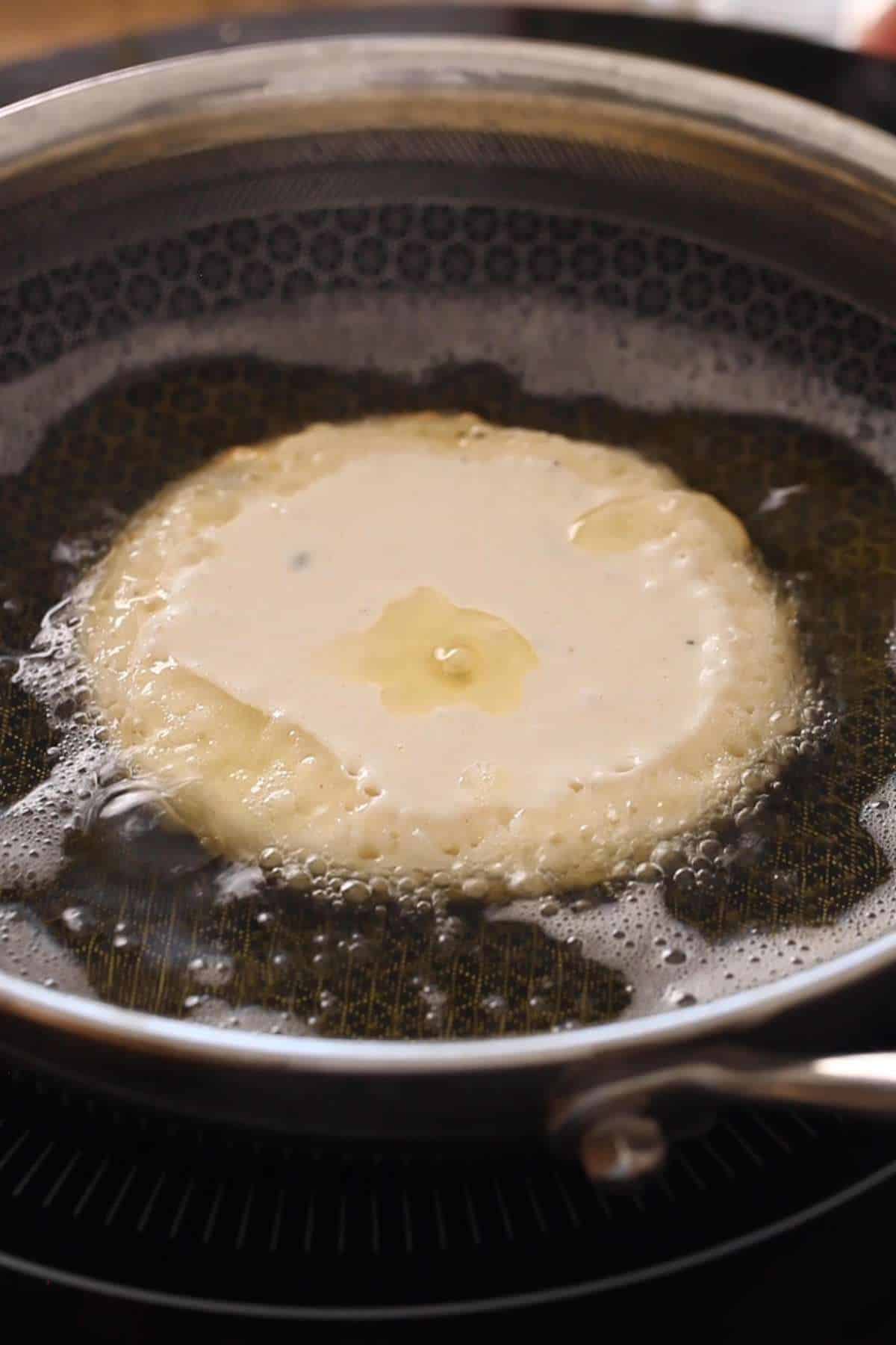 Malpua getting fried in ghee.