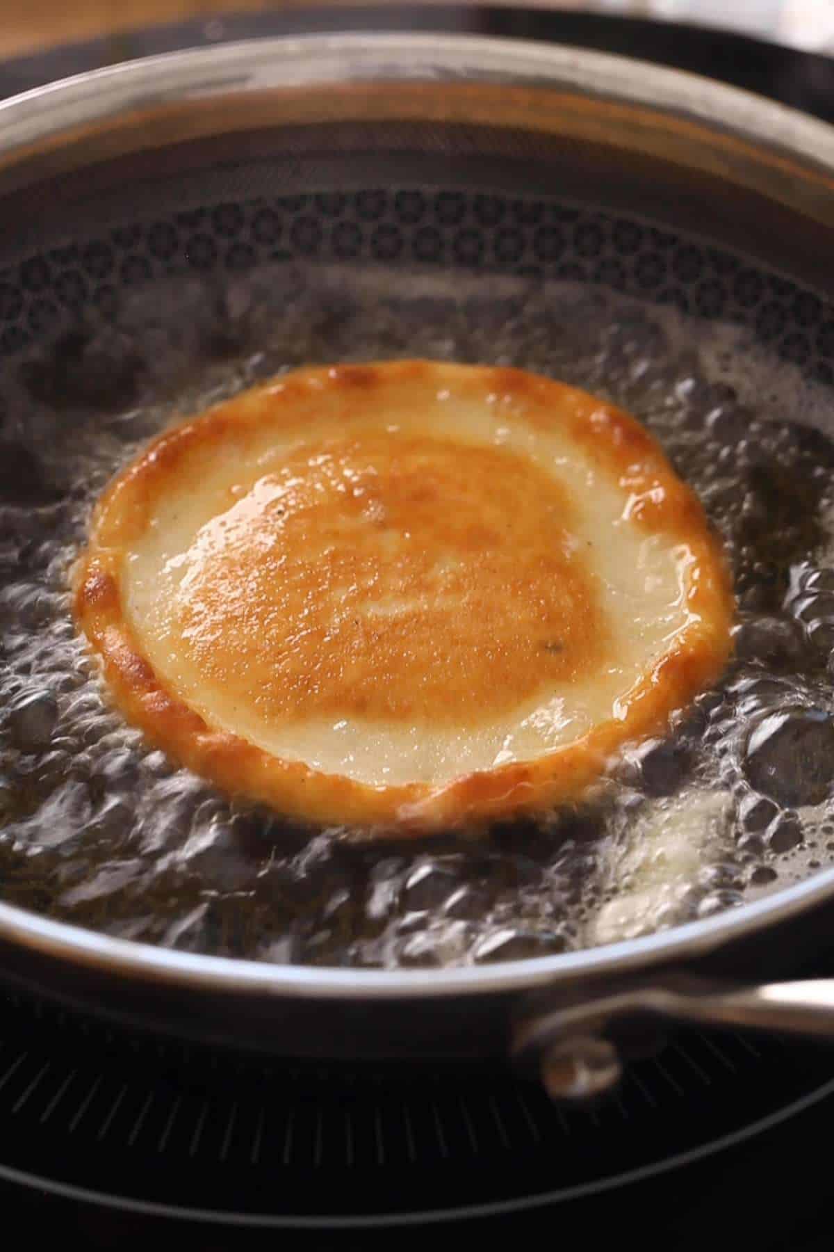 Golden brown indian pancake sizzling in ghee.