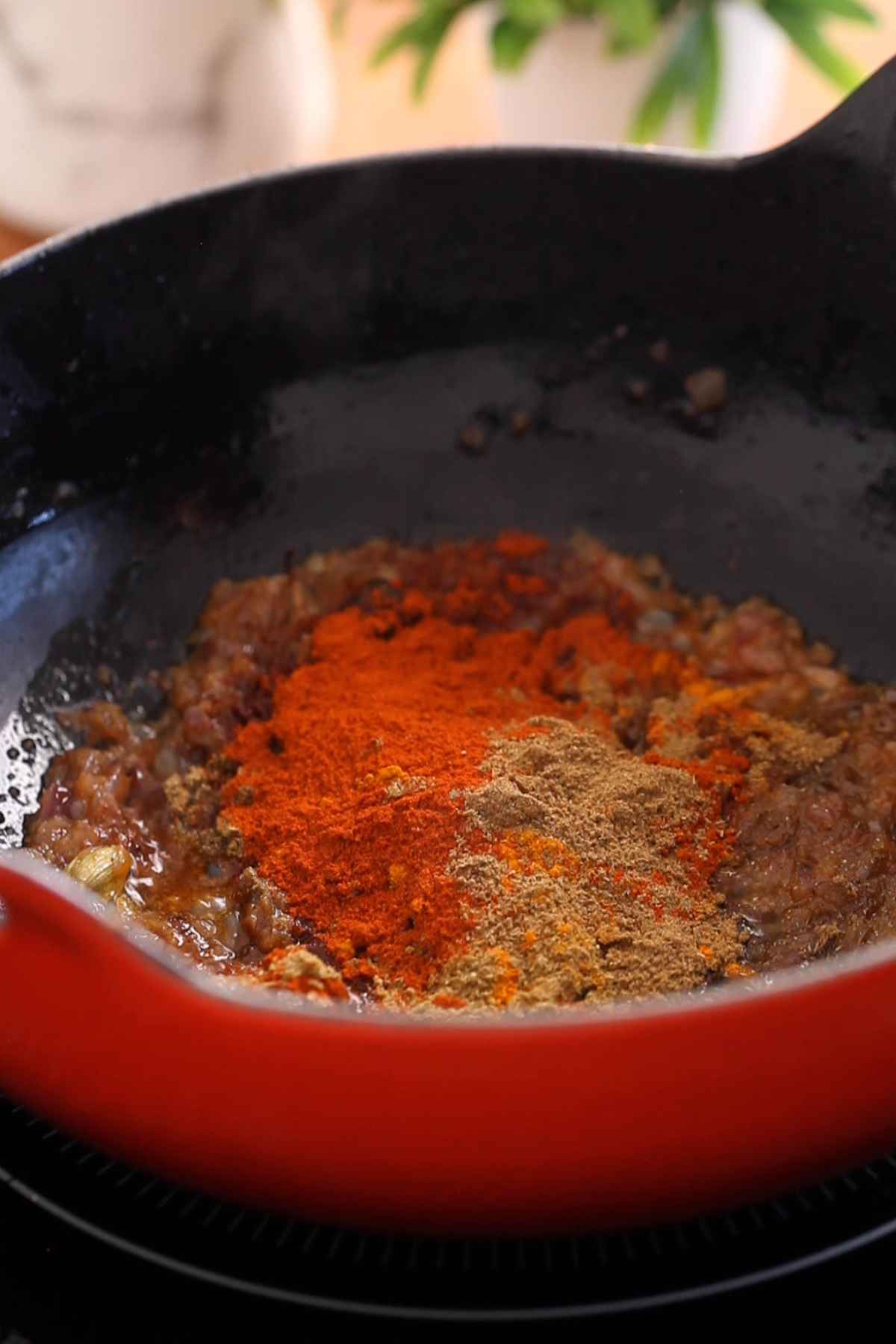 Ground spices are added to browned onions.