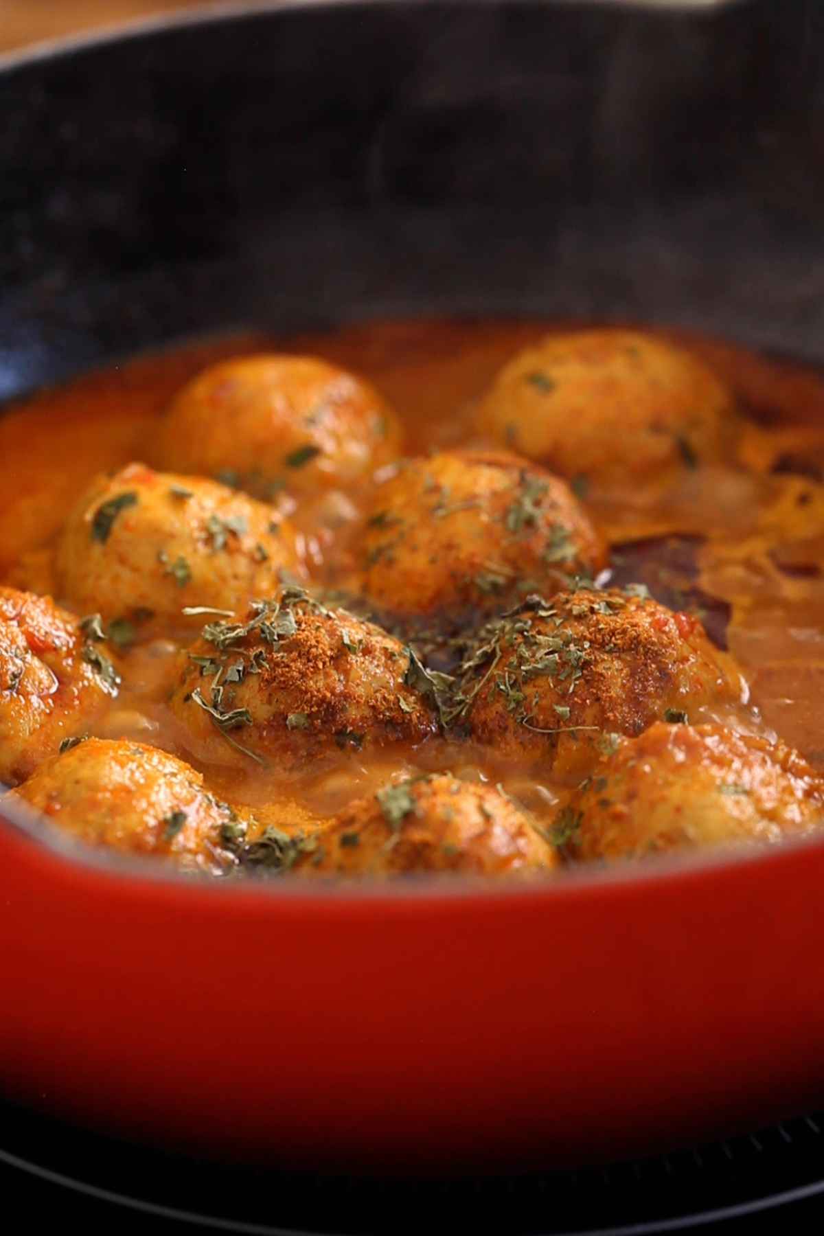 Chicken meatball curry is finished with spices and dried herbs.
