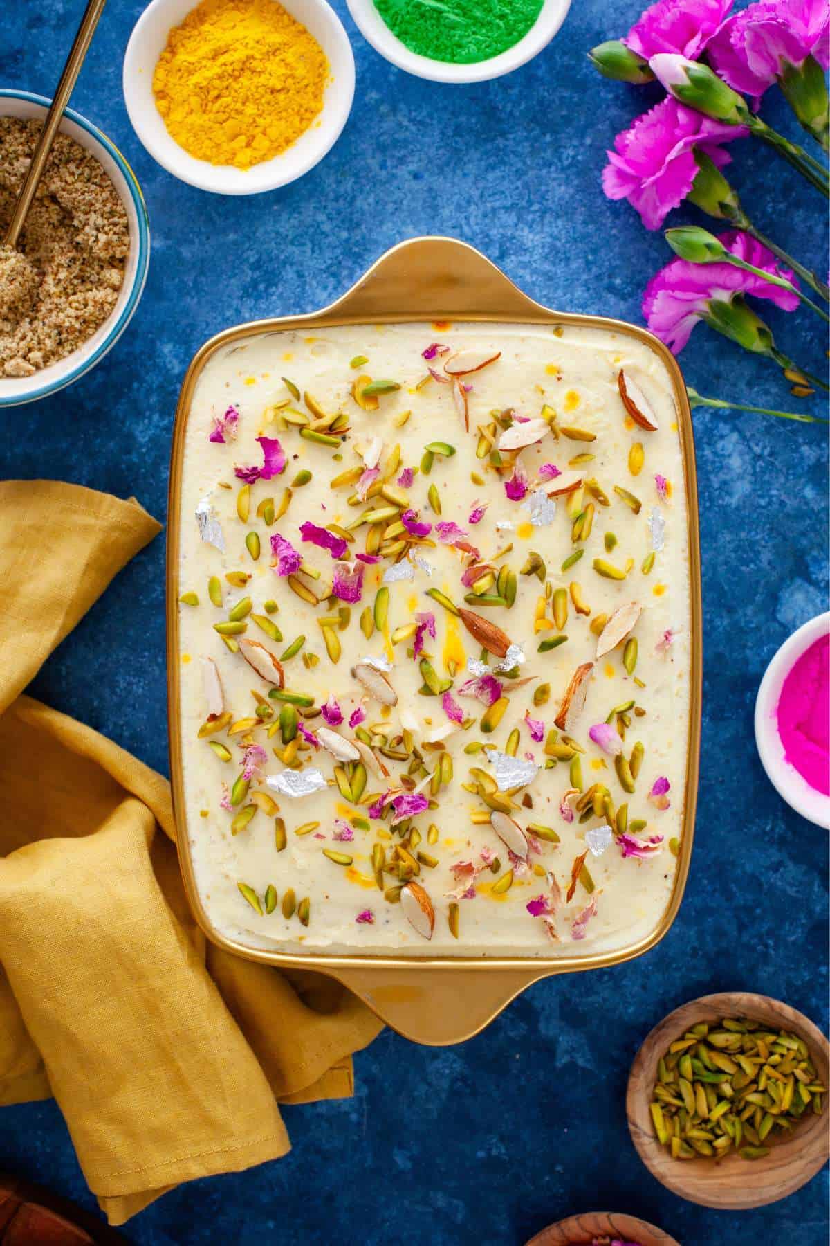 Thandai dessert set in a gold tray and place on a Holi table with holi powder and flowers.