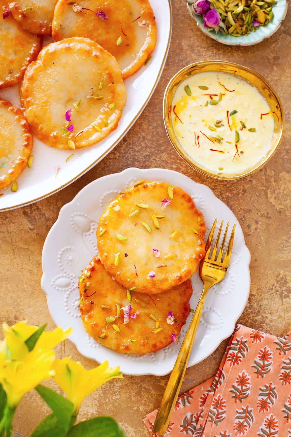 Malpua and rabdi served on a gold background.