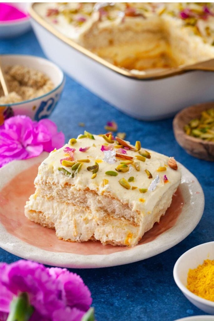 A slice of thandai tiramisu on a pink plate. 