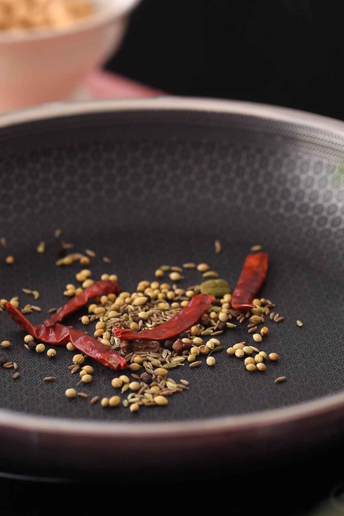 Dry roasting whole spices to make chana masala.