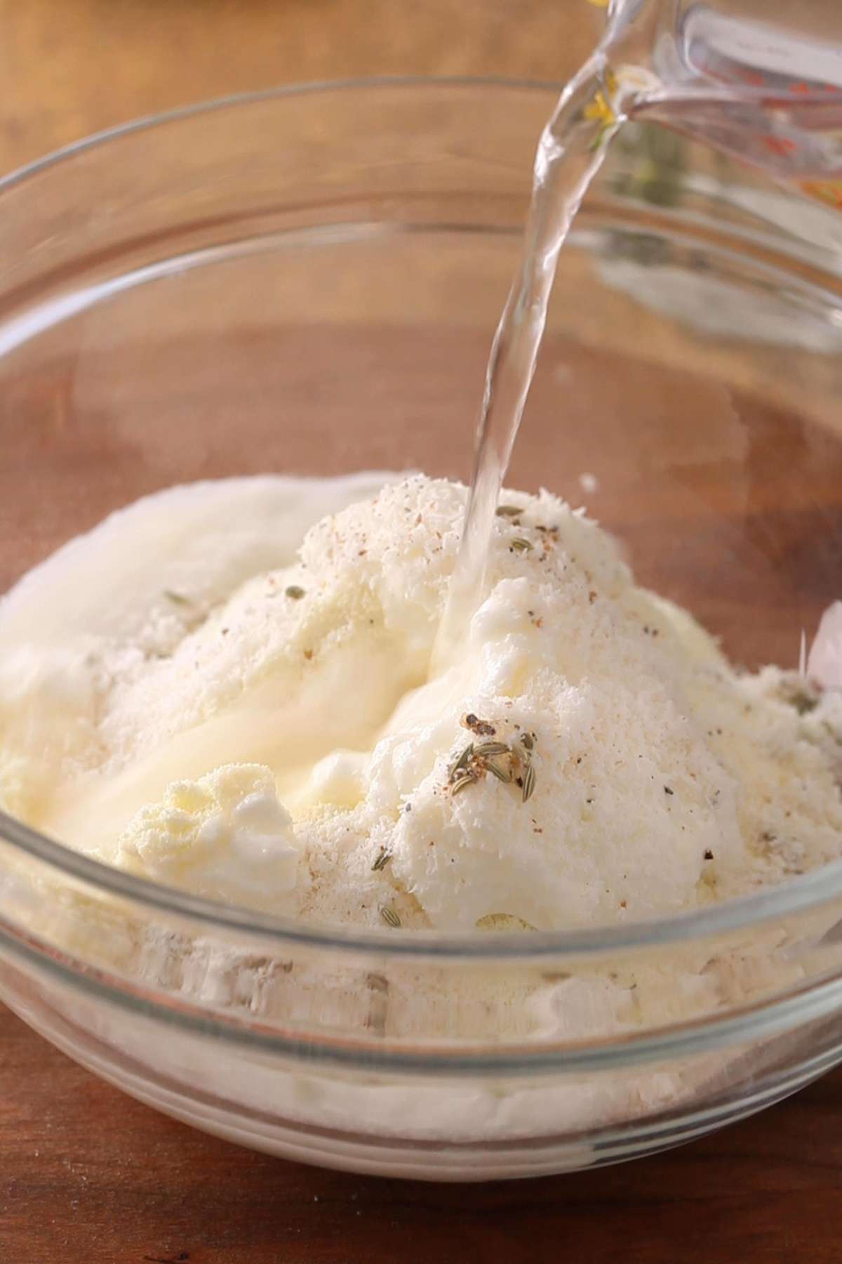 Adding water to make an indian pancake batter.