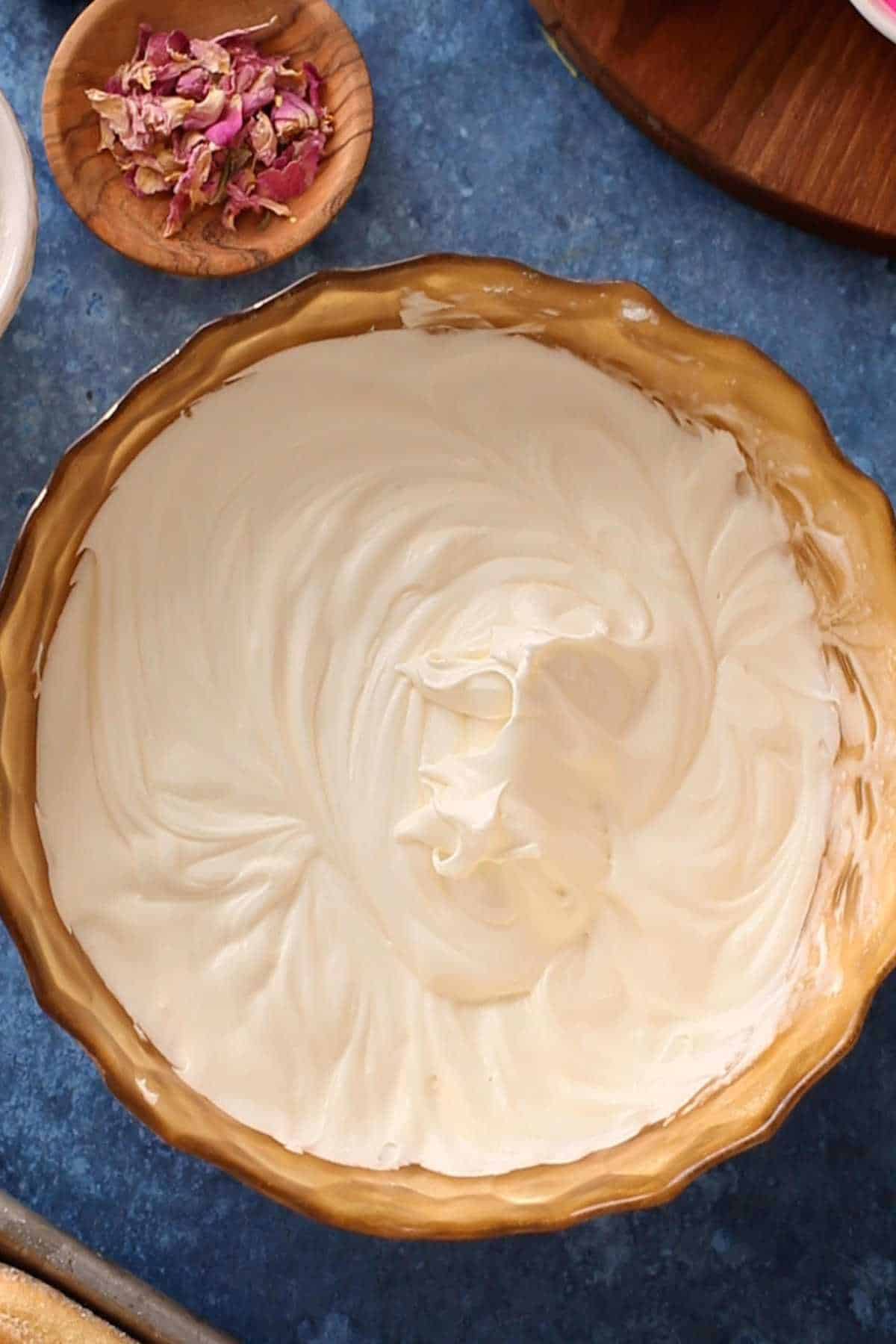 Whipped mascarpone cream in a gold bowl.