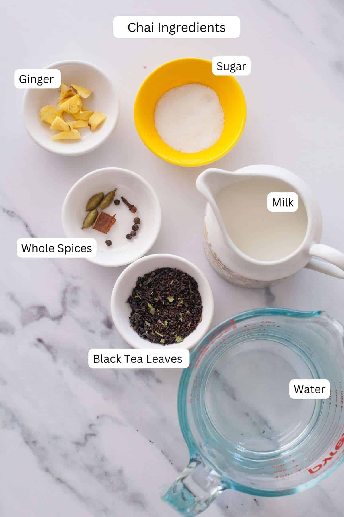 Ingredients for Masala Chai on a marble background.