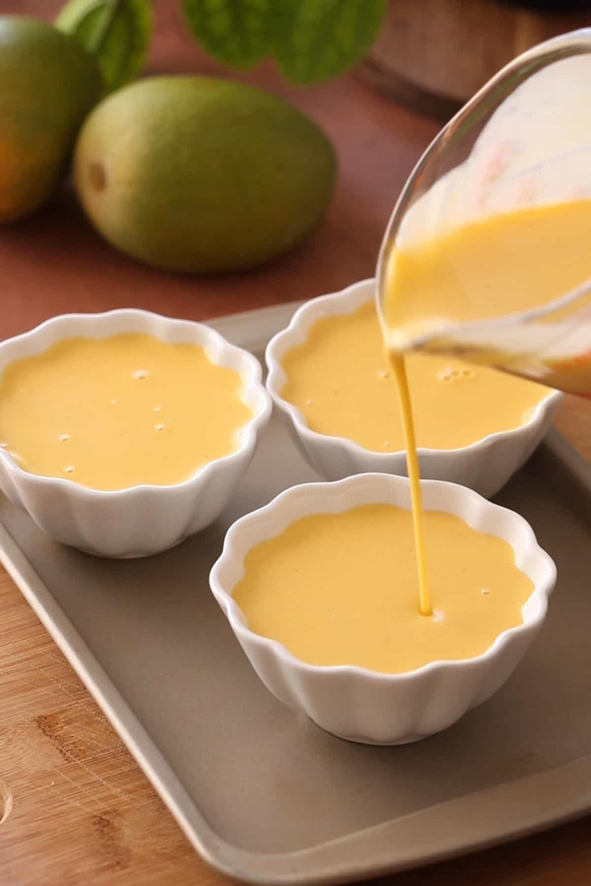 Panna cotta mixture is poured into ramekins to set.