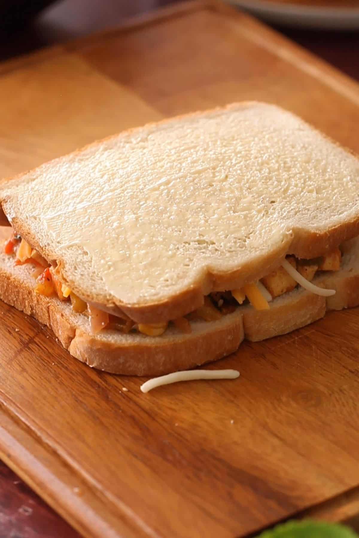 Buttered sandwich with paneer filling inside.