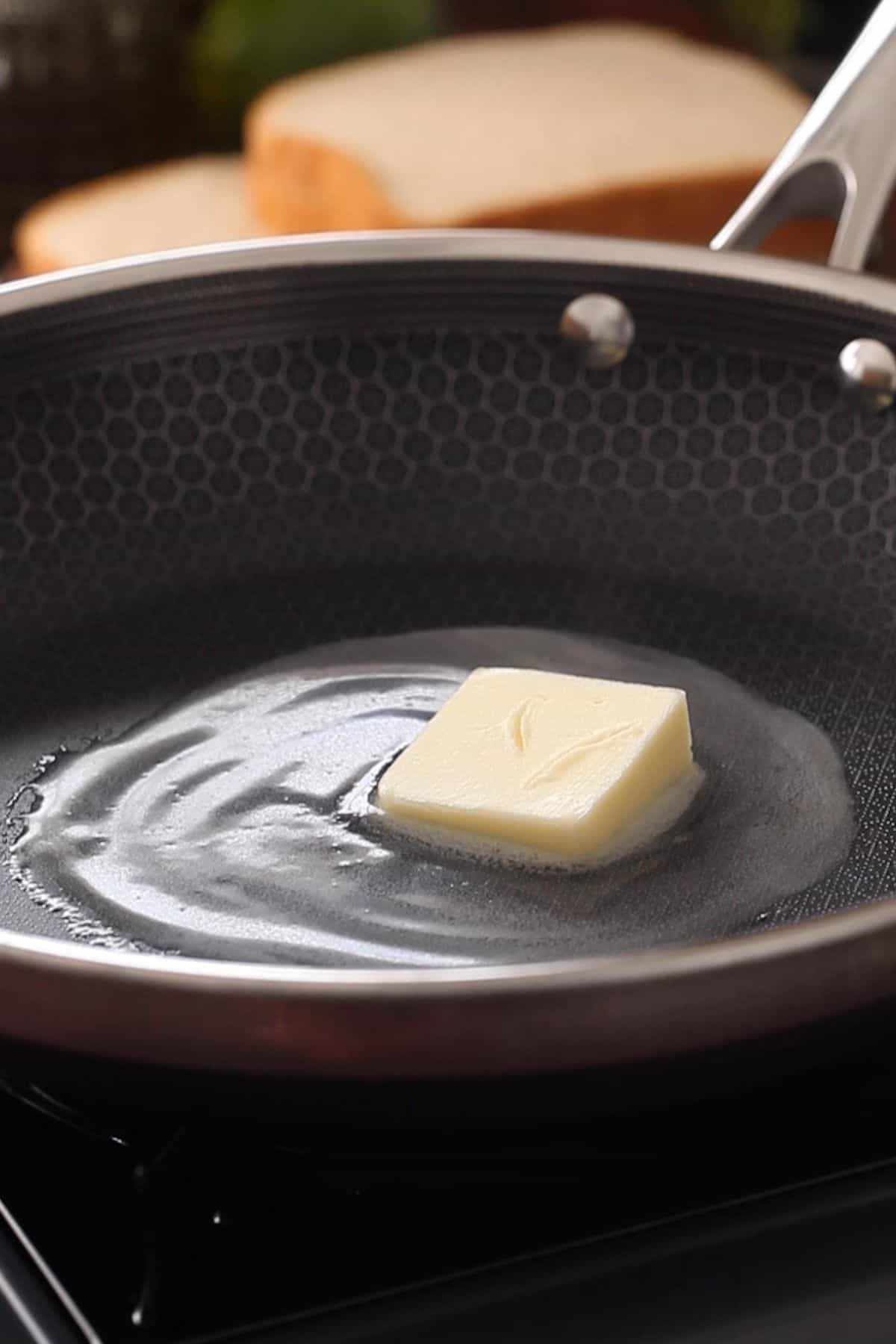 Melting butter in a black skillet.
