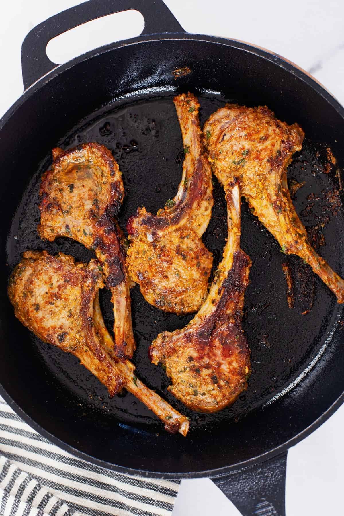 Pan seared lamb chops in a cast iron skillet.