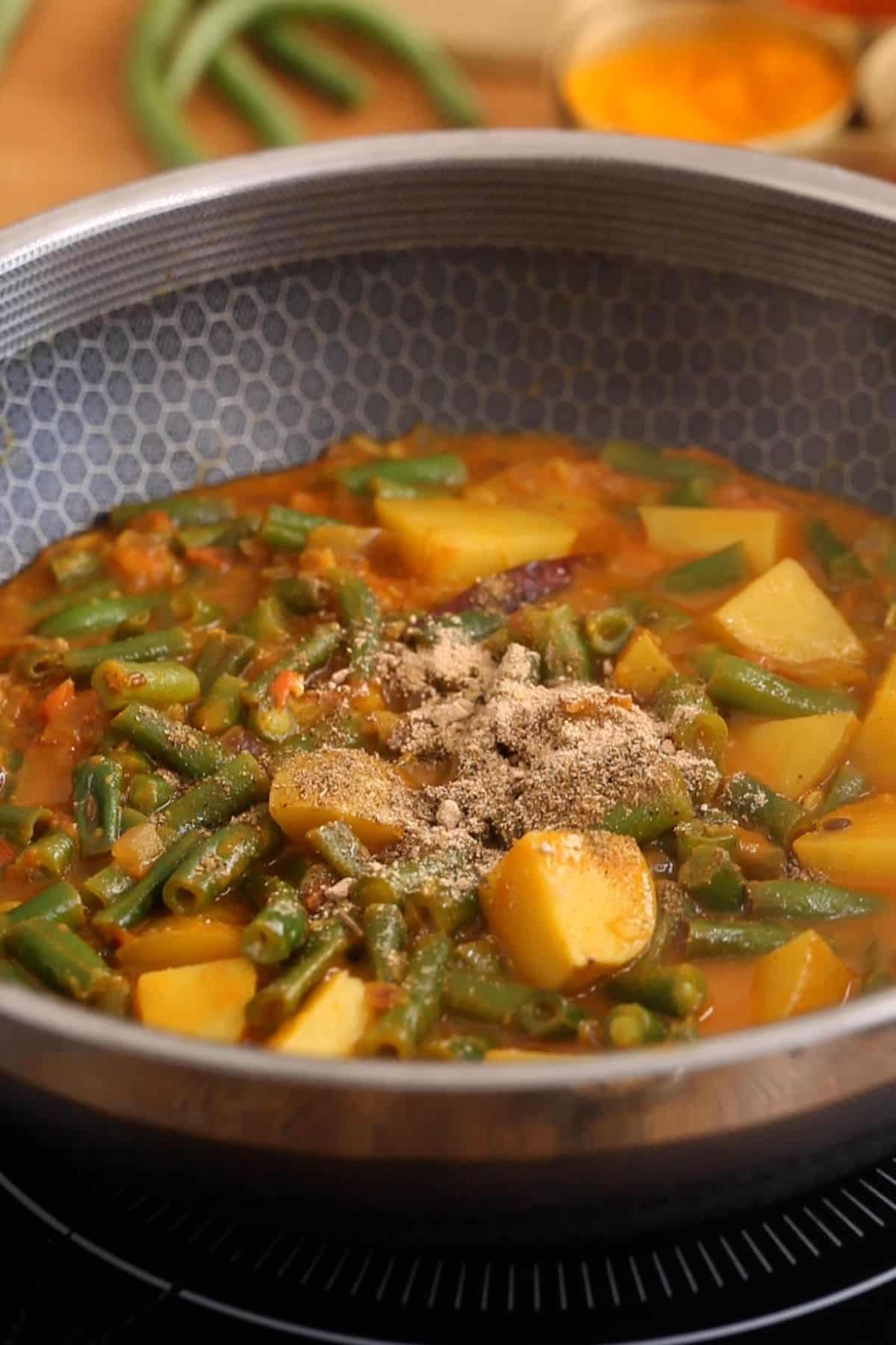 Green bean saloo is finished with garam masala and dry mango powder.