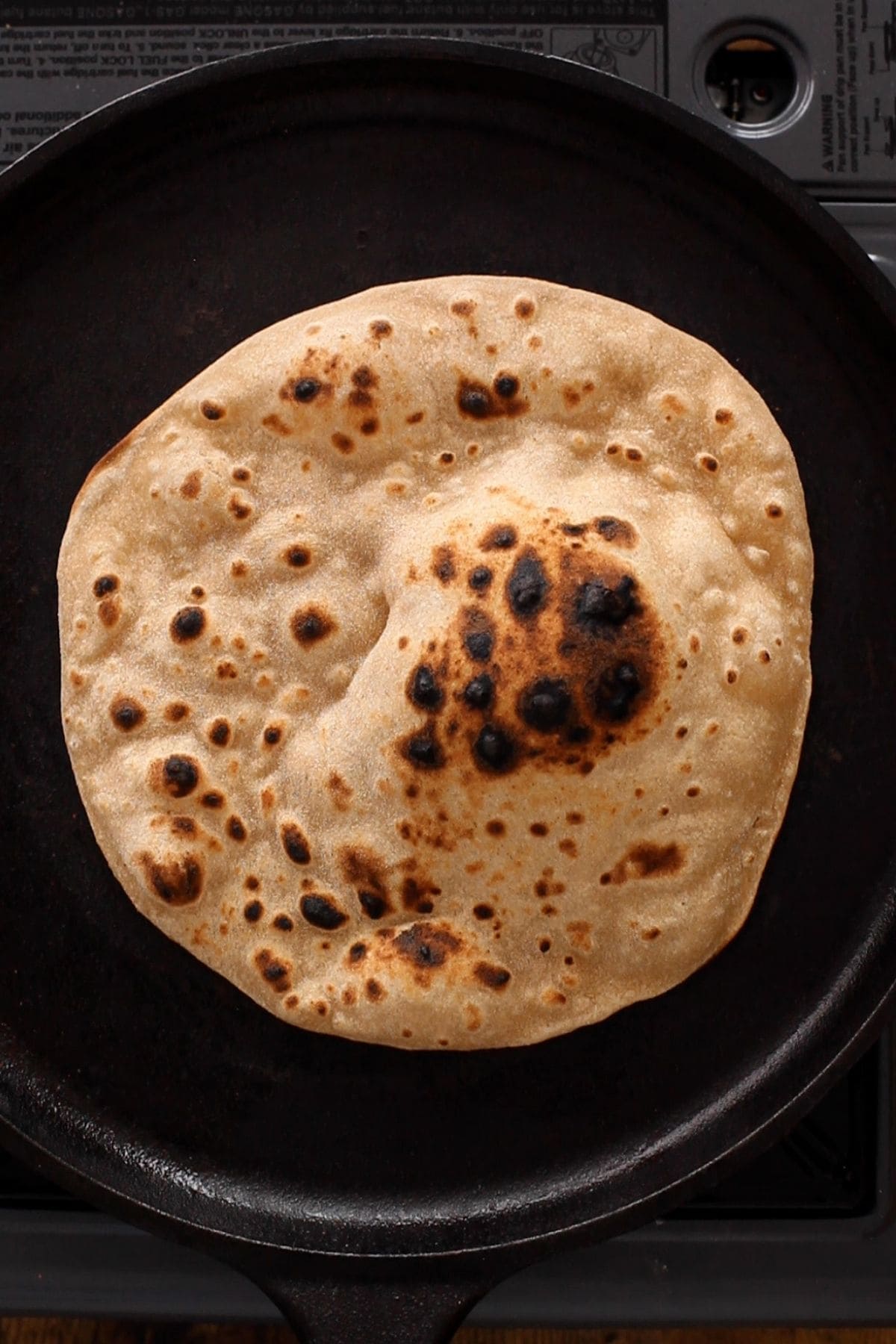 Cooked tandoori roti on a cast iron tawa.