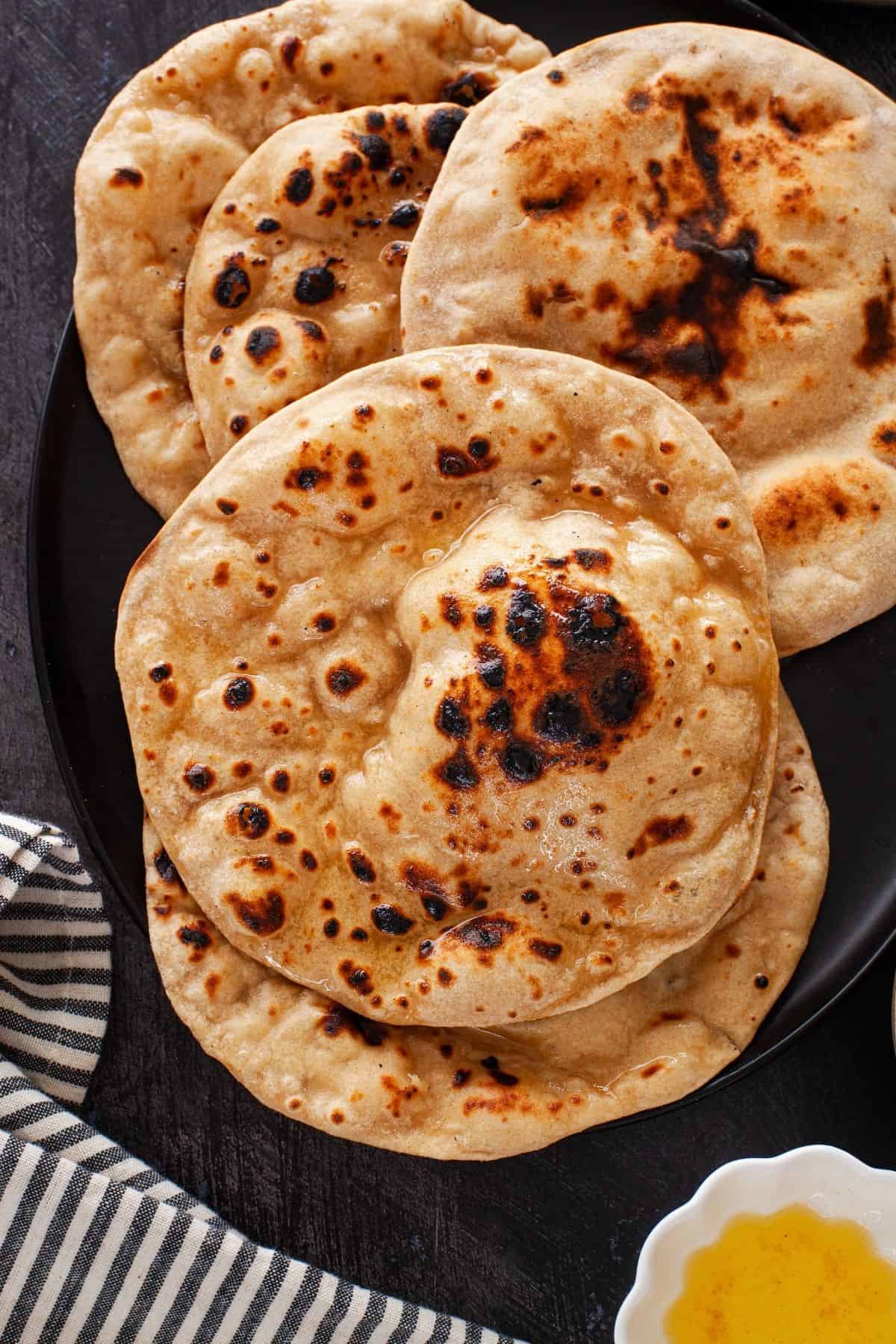 Overhead image of tandoori rotis smeared with ghee.