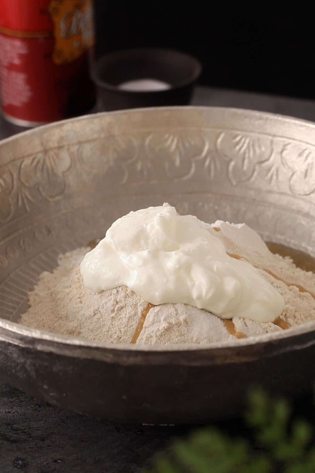 Flour with roti ingredients in a large silver mixing bowl.