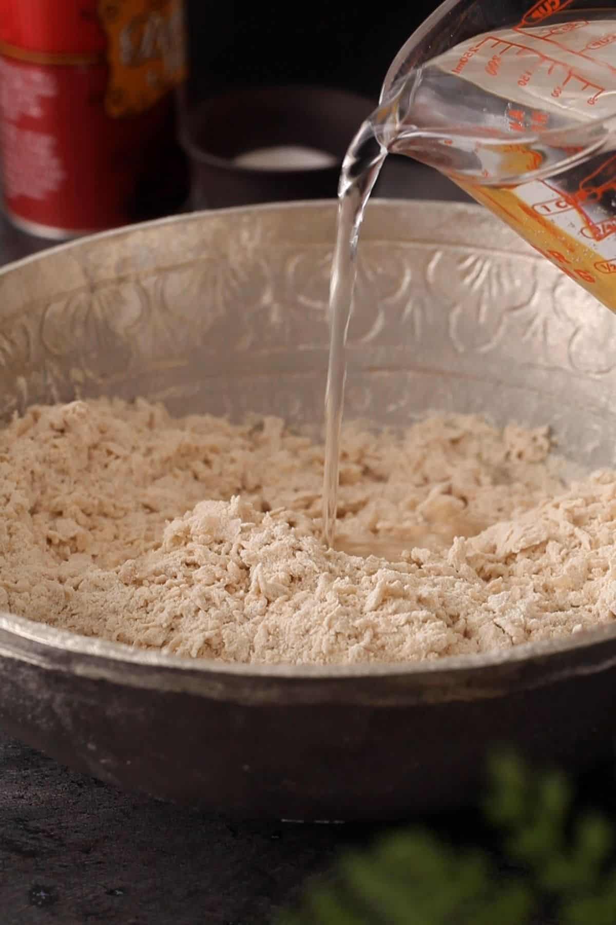 Adding water to knead the dough.