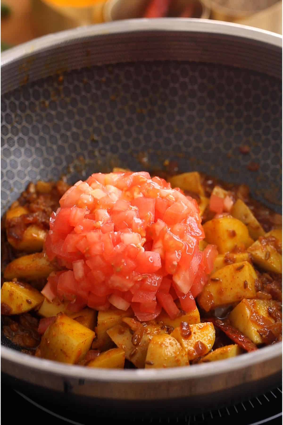 Chopped tomatoes added to the potatoes.