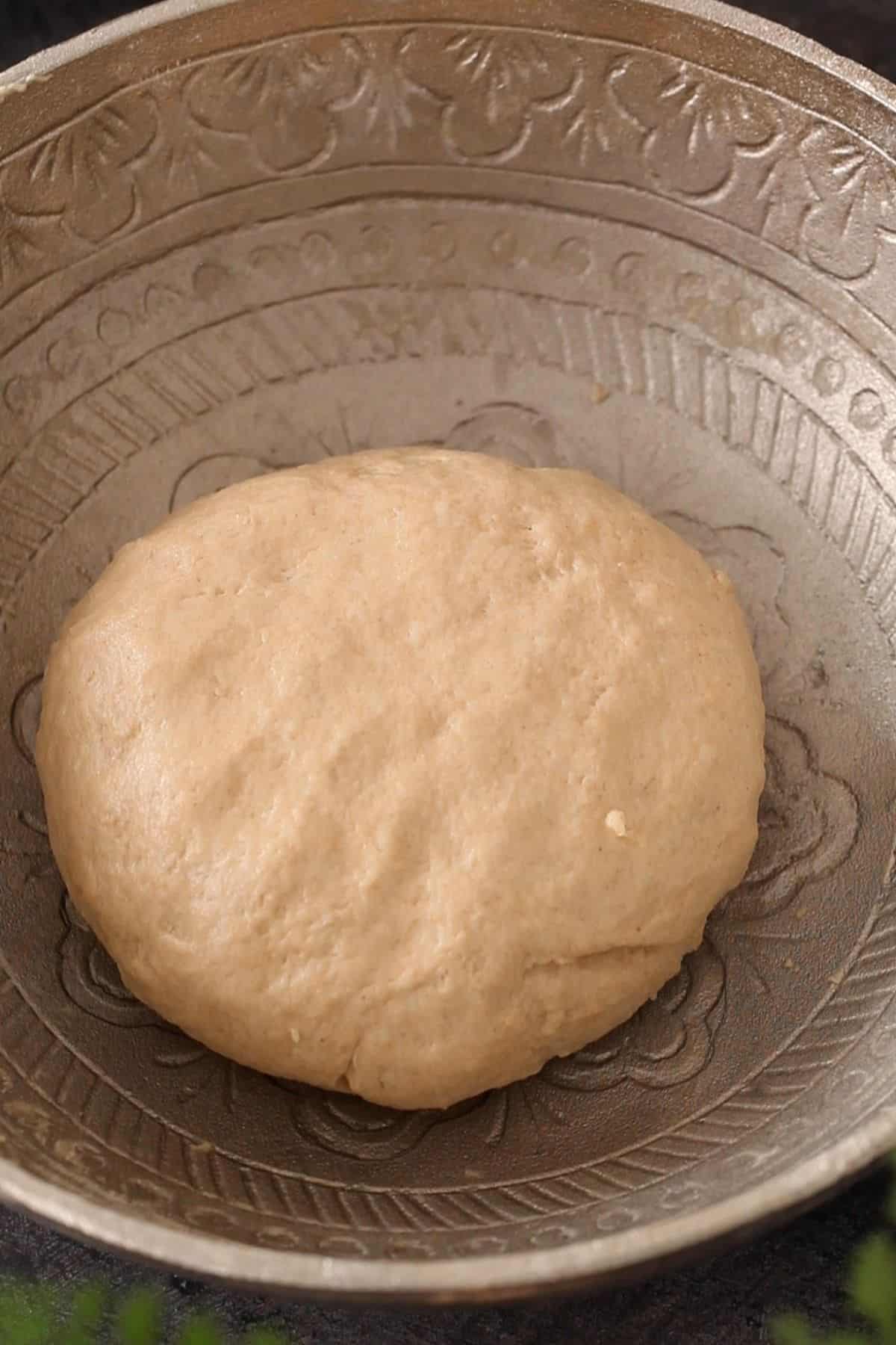 Smooth dough for roti in a silver bowl.