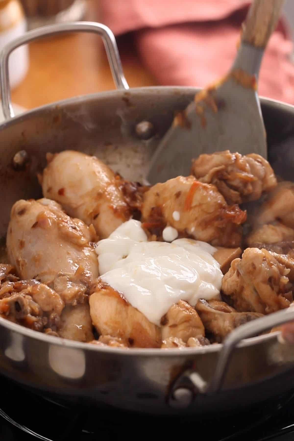 Yogurt is added to seared chicken.