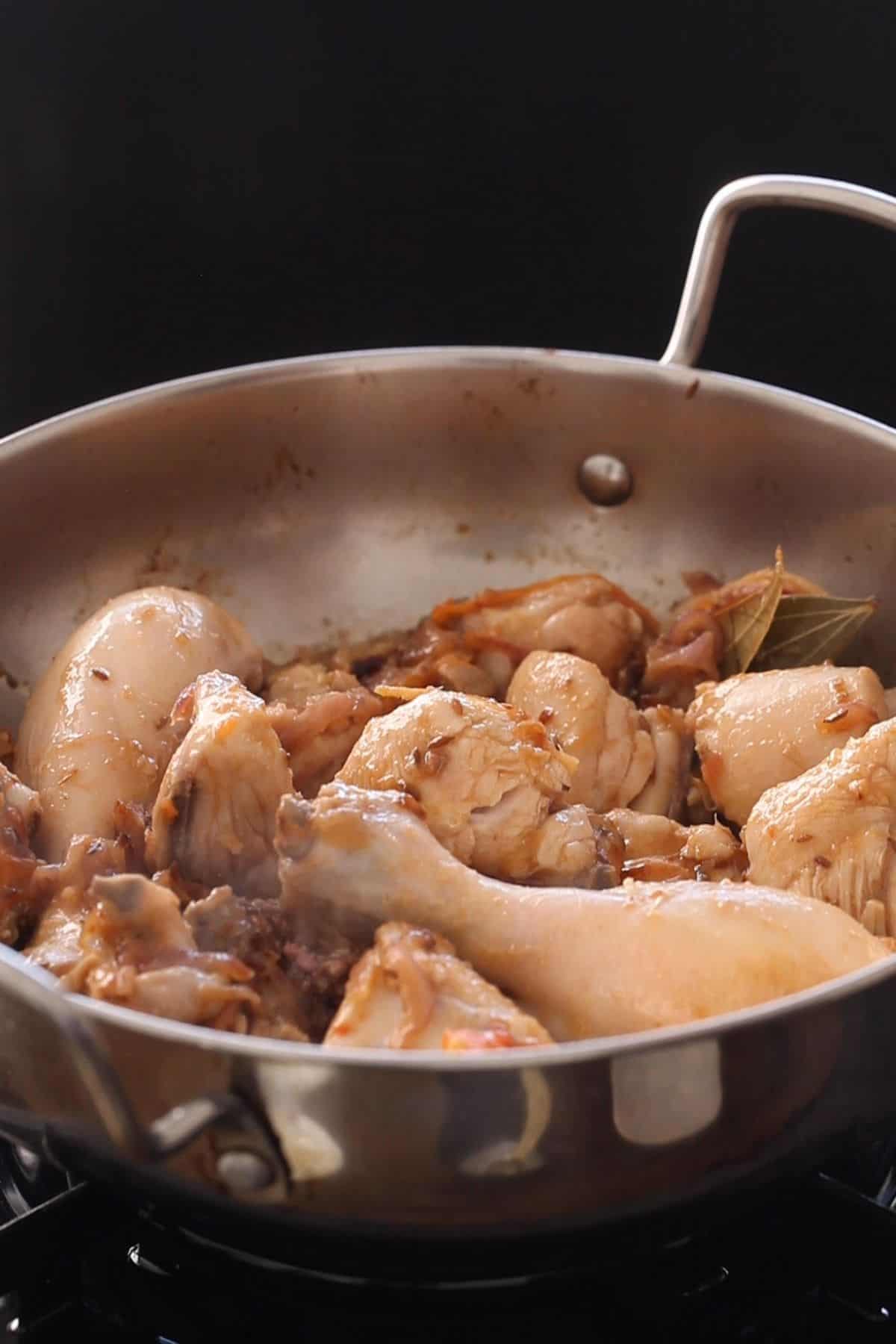 Seared chicken after cooking with onion and spices.