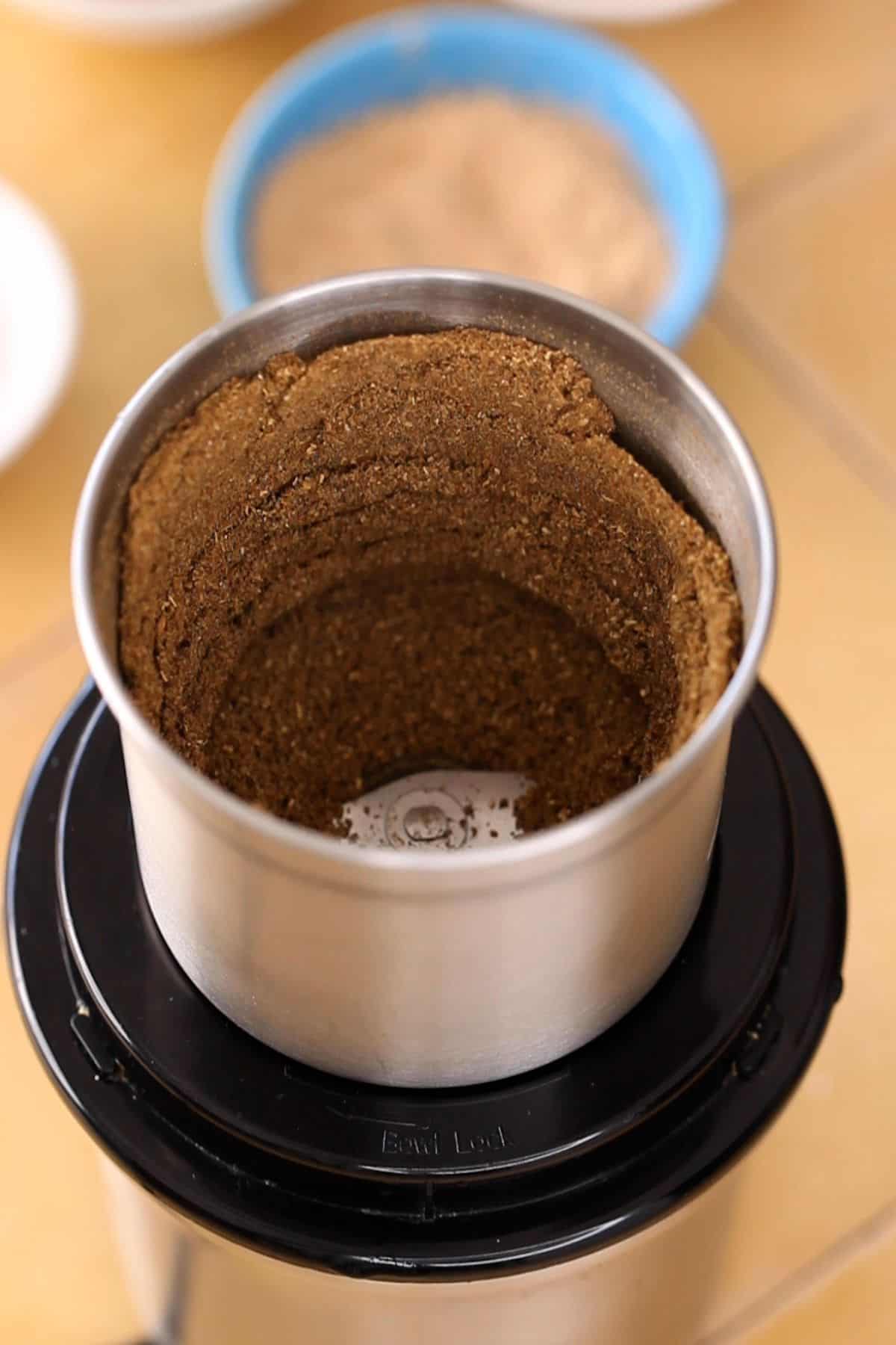 Whole spices are ground to a fine powder.