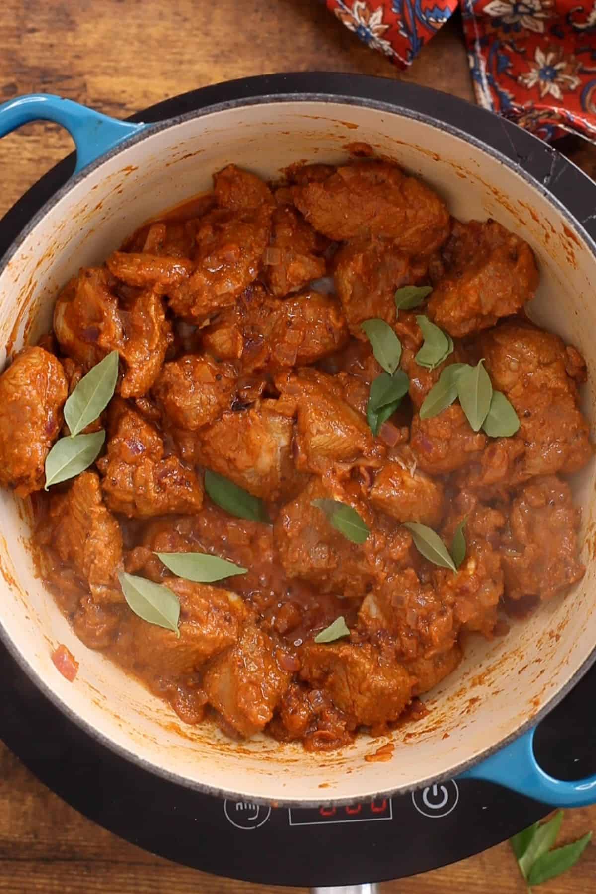 Add curry leaves to the seared meat.