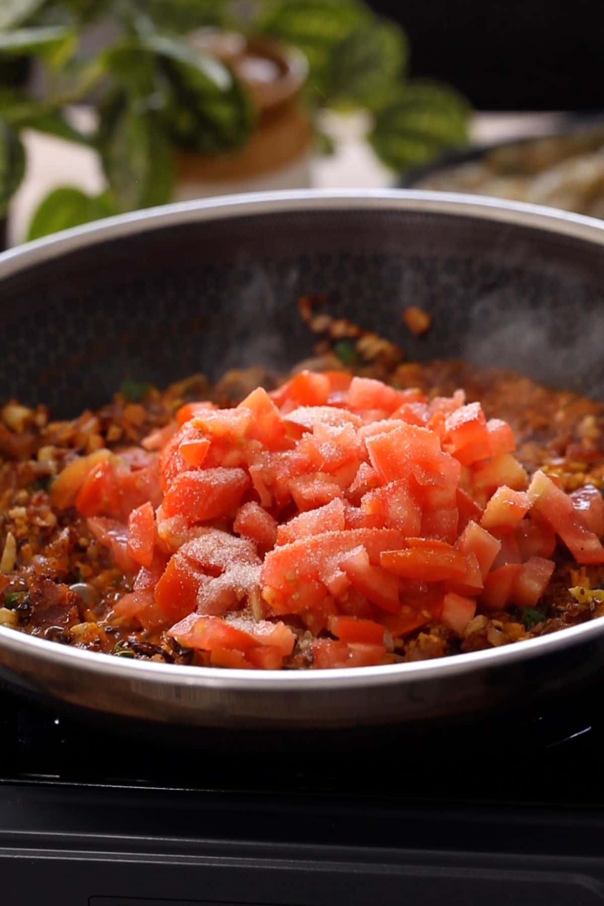 Tomatoes and salt are added to make masala for bharta.