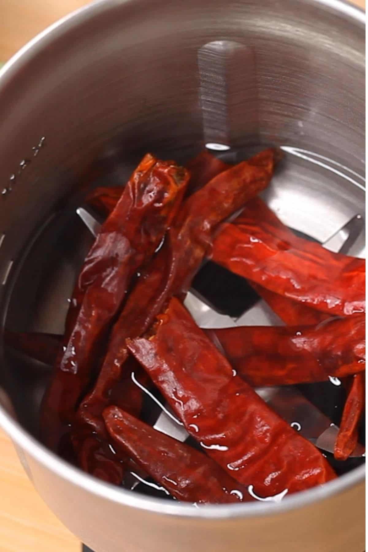 Soaking dry red chilies in hot water in a blender jar.