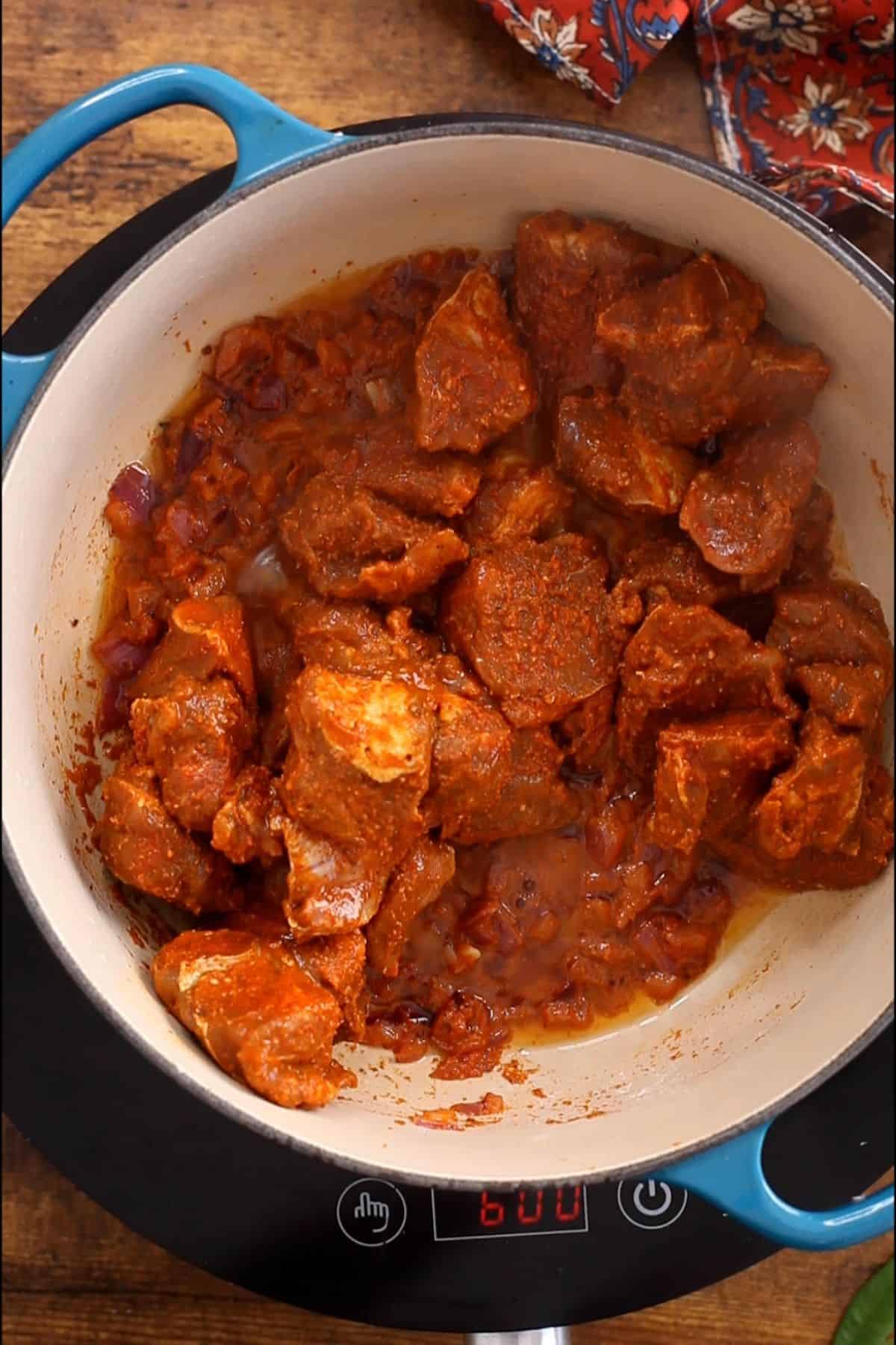 Add marinated lamb to the cooking pot.