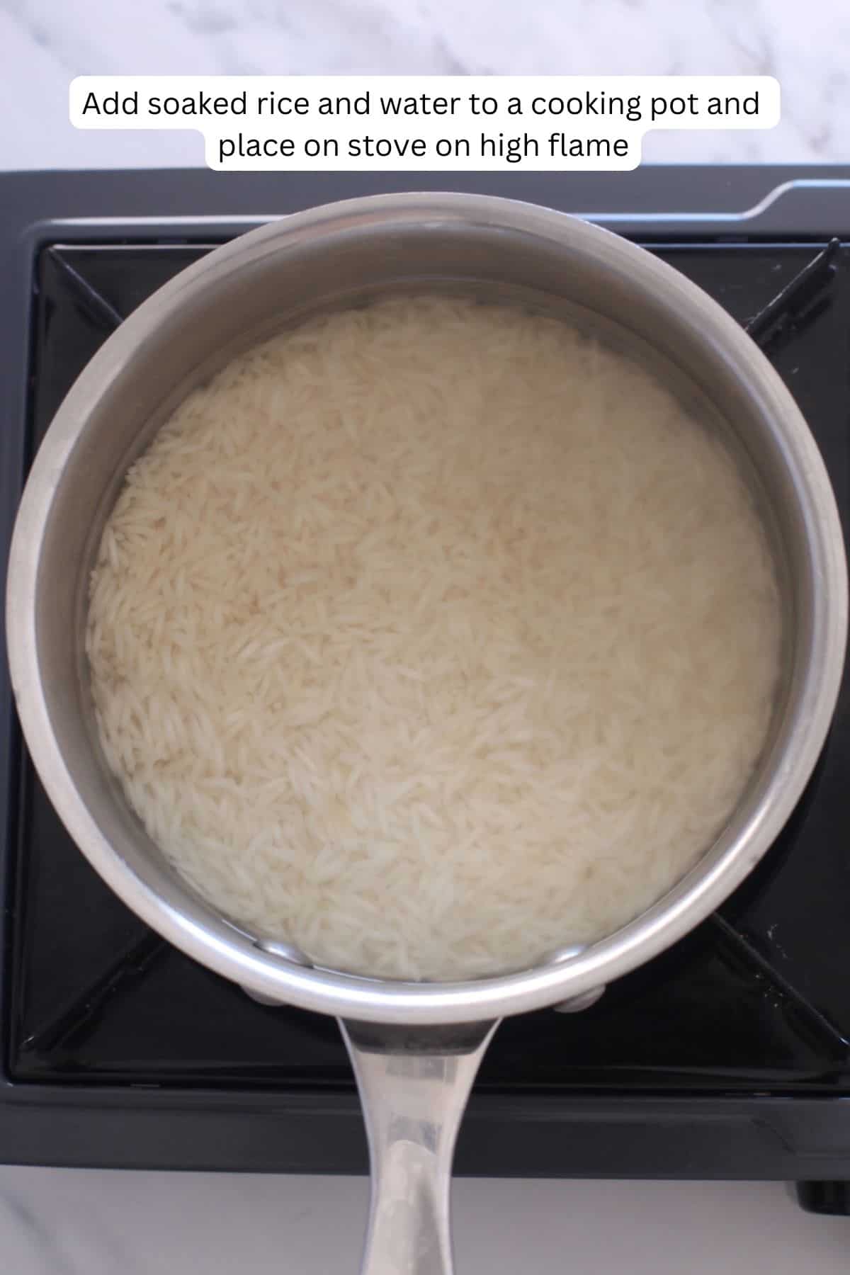 Soaked rice and water placed in a stainless steel cooking pot.