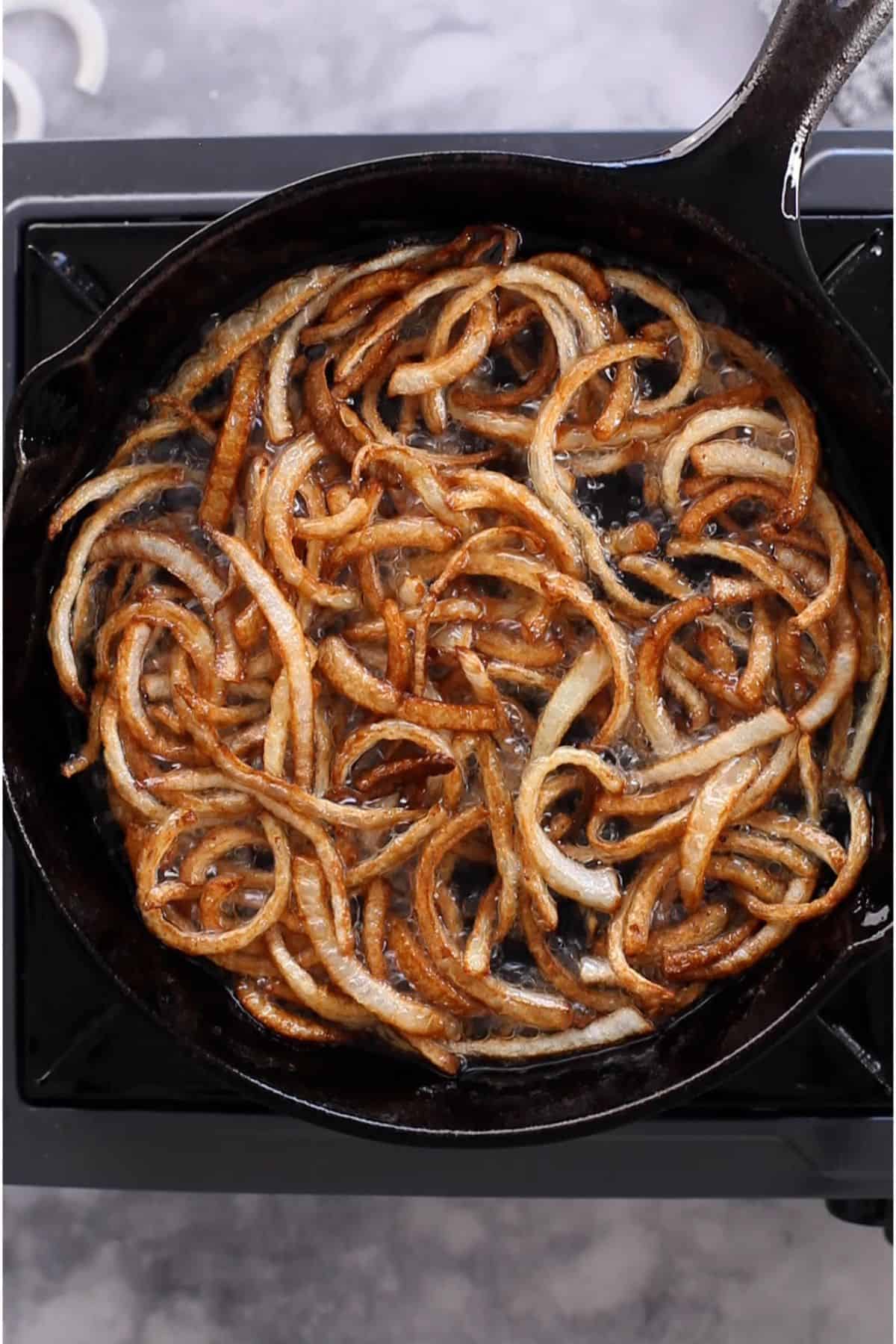 Golden brown deep fried onions in hot oil. 