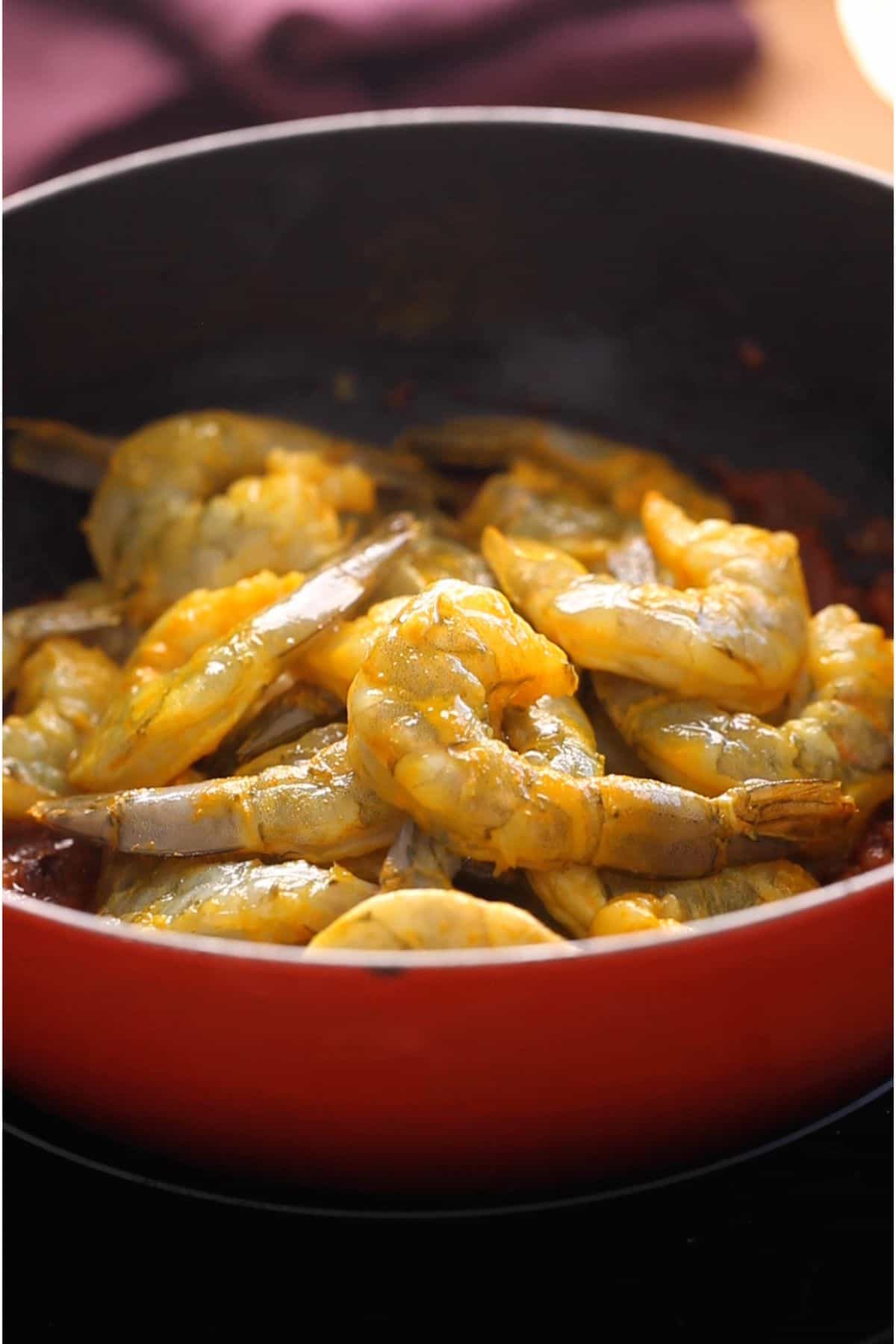 Raw marinated shrimp is added to the masala.