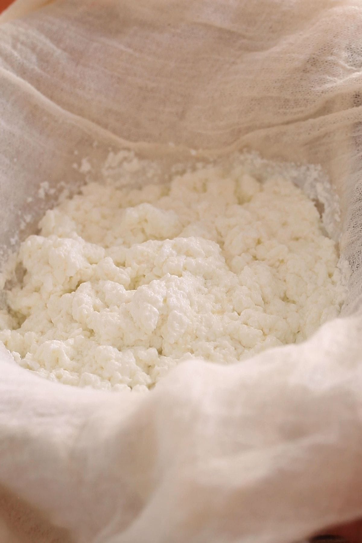 Straining chenna using a cheese cloth.