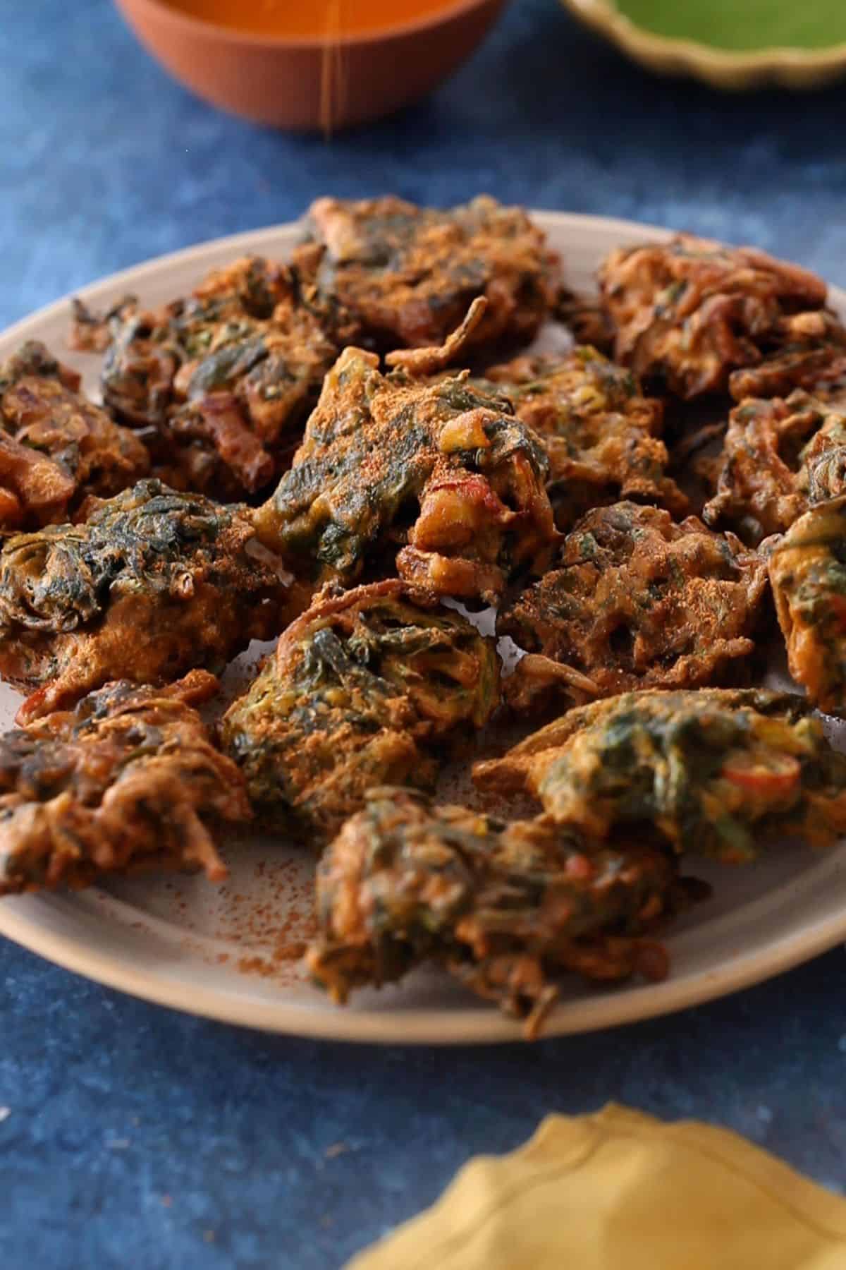 Chaat masala is sprinkled over palak pakoras.