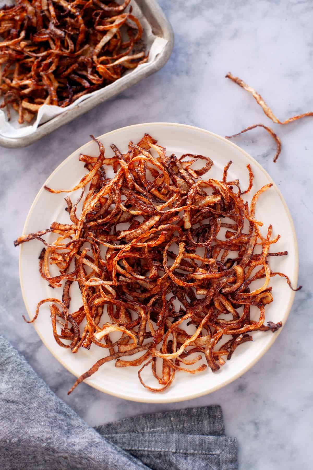 Indian Style Fried Onions placed on a beige plate.