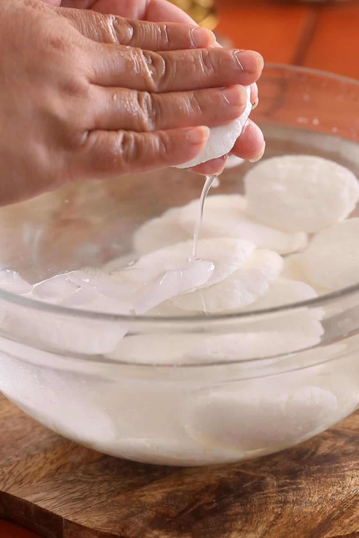 Squeeze the excess water out of the rasmalai patties.