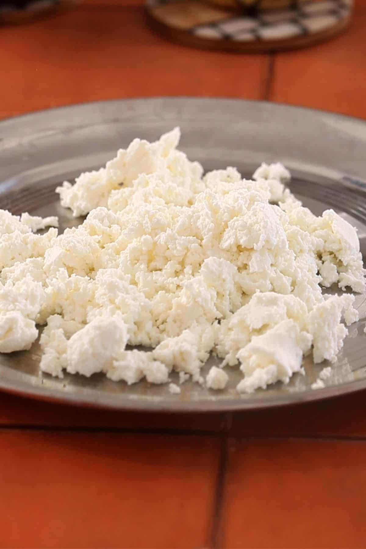 Crumbled chenna on the steel plate.