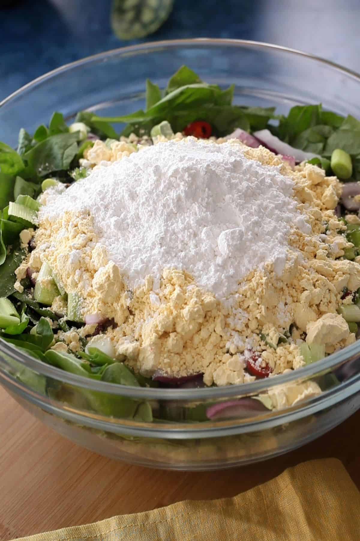Besan and rice flour are added to the bowl.