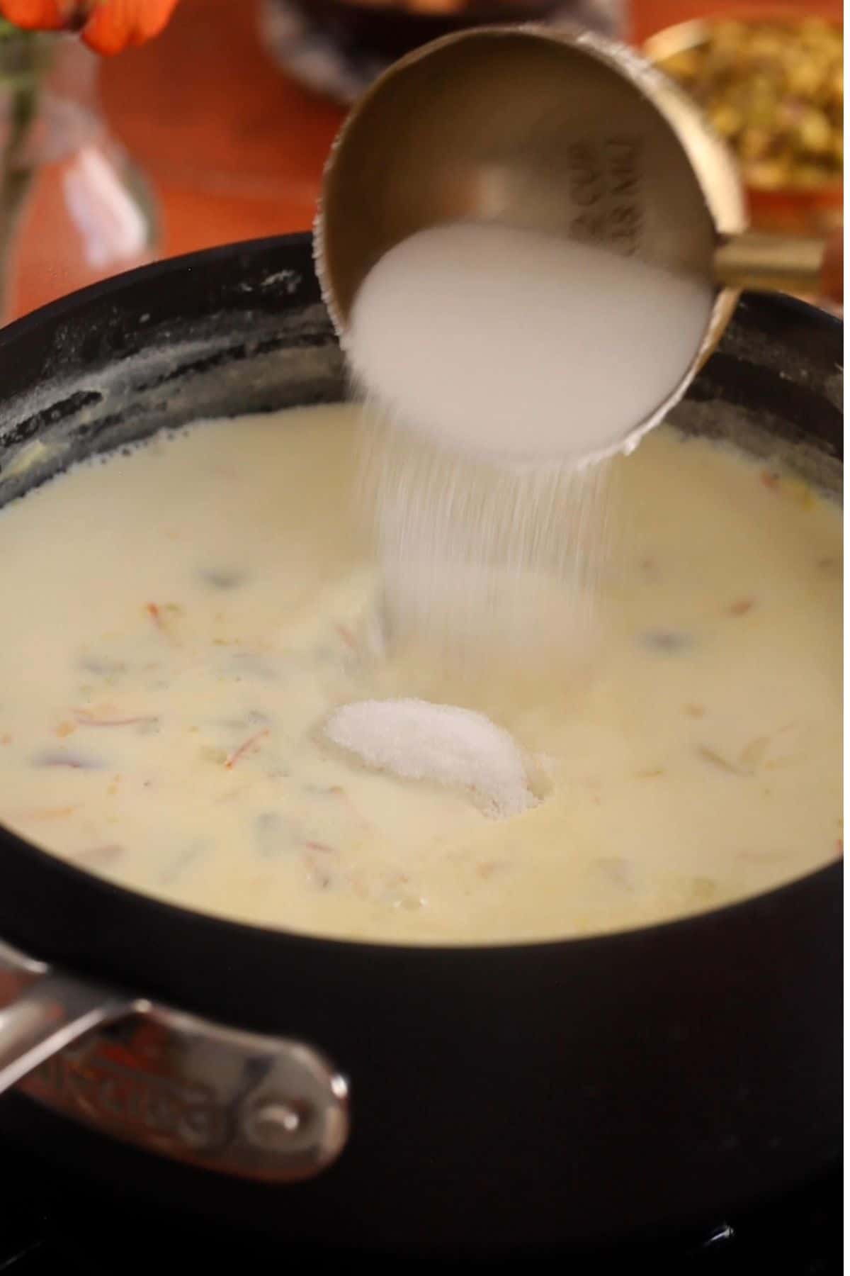 Sugar is being added to the milk.